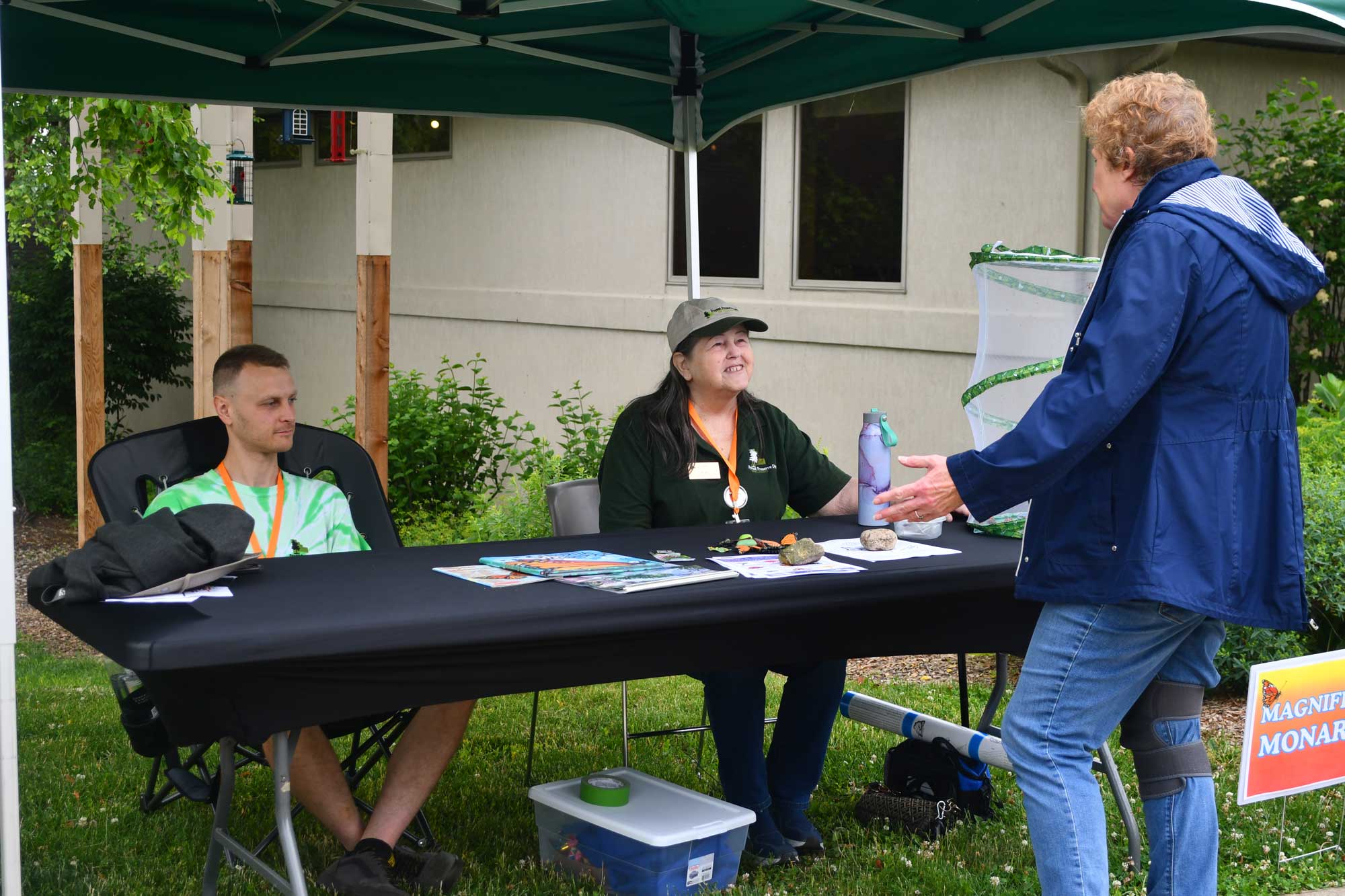 People assisting person at information table at a program.