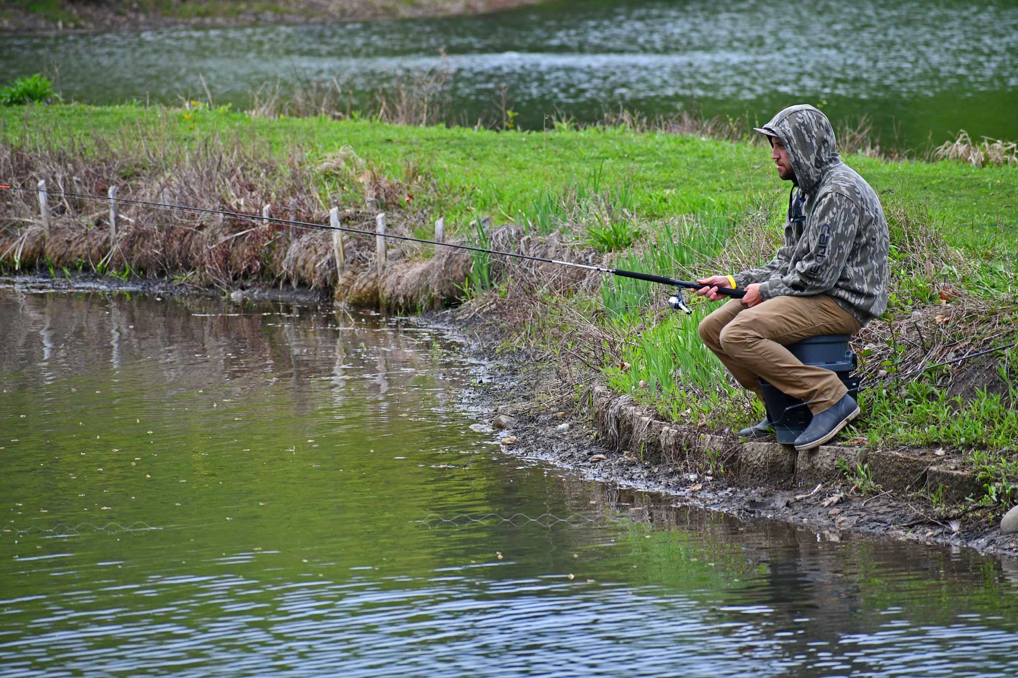 Person sitting down and fishing.
