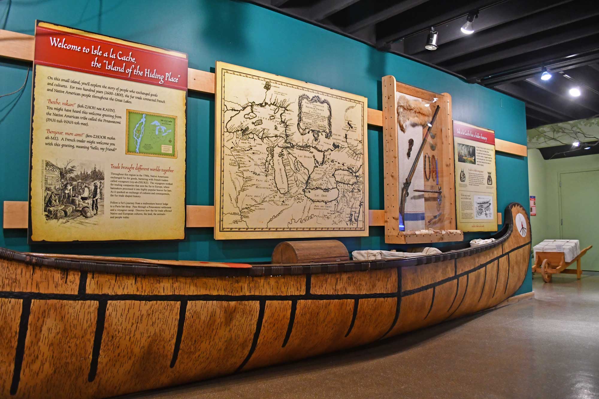 Exhibit display of a canoe and exhibit panels inside of a museum.