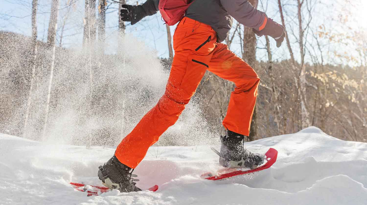 a person in orange snowsuit and orange pants snowboarding