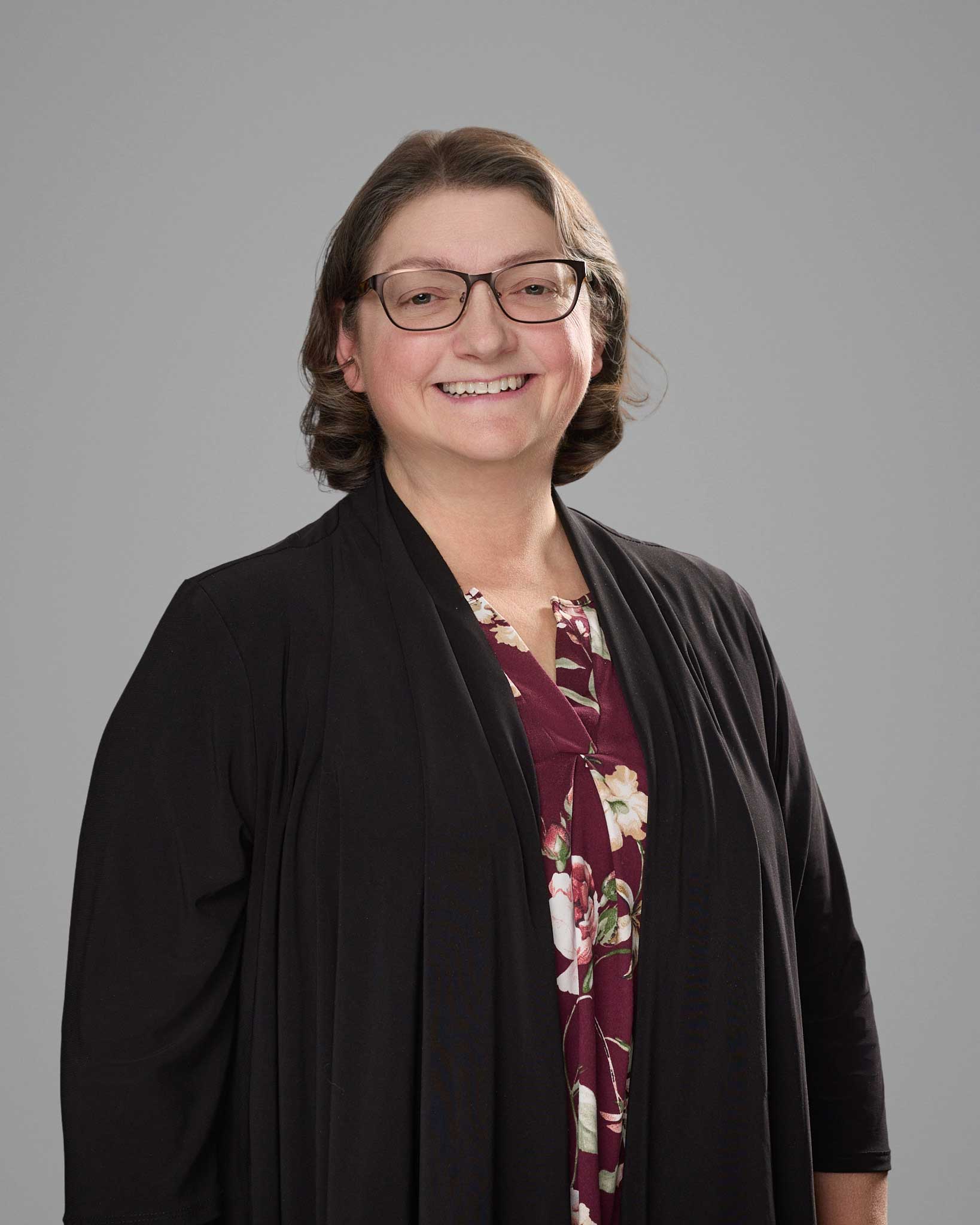 a woman wearing glasses and a black jacket