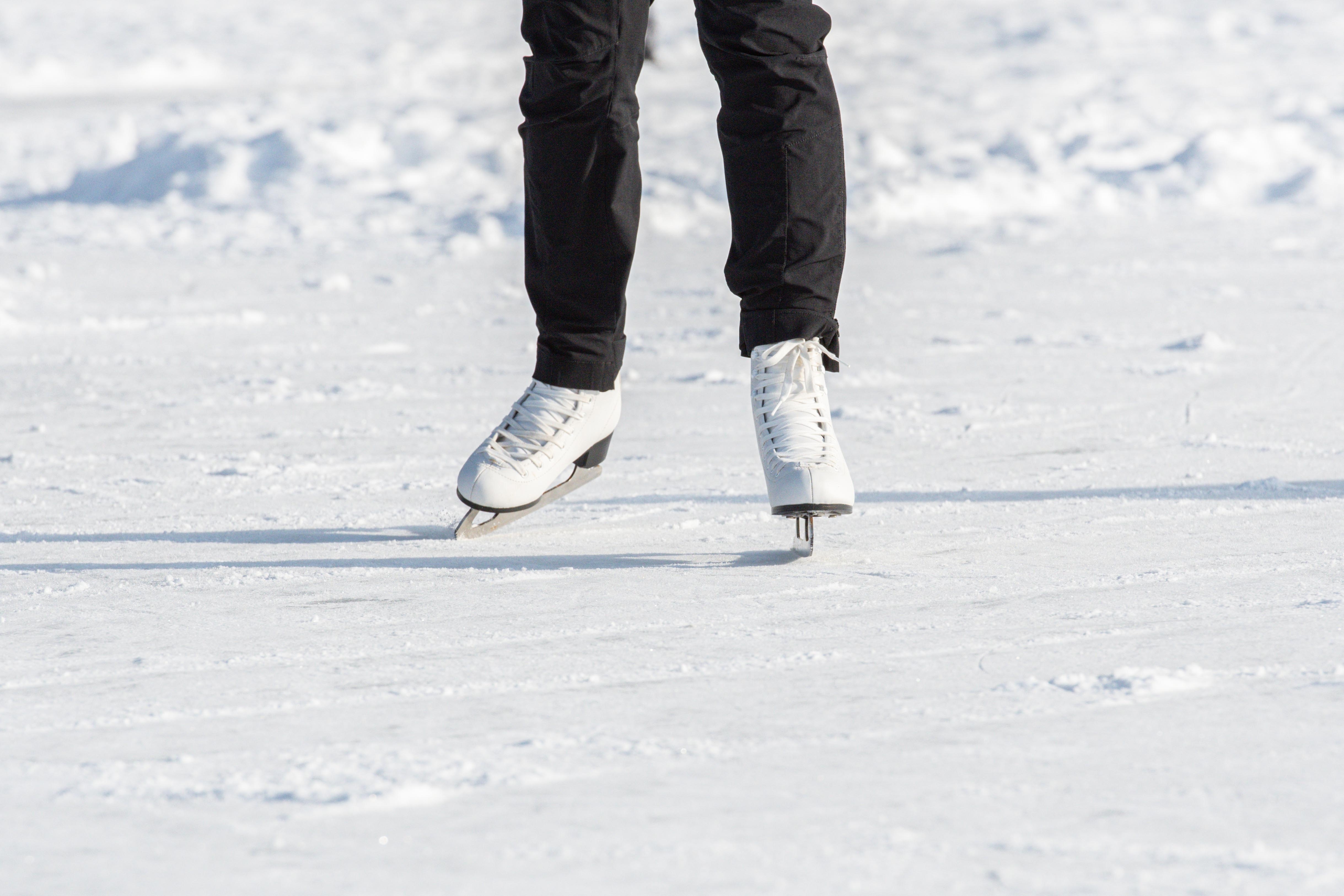 a person's legs in ice skates on snow