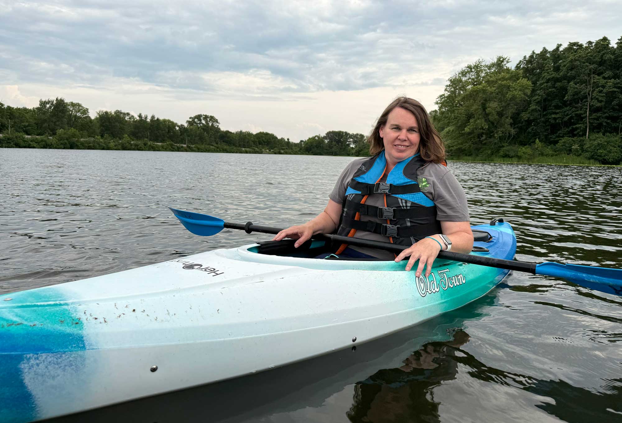 A person wearing a life jacket in a kayak on the water. 