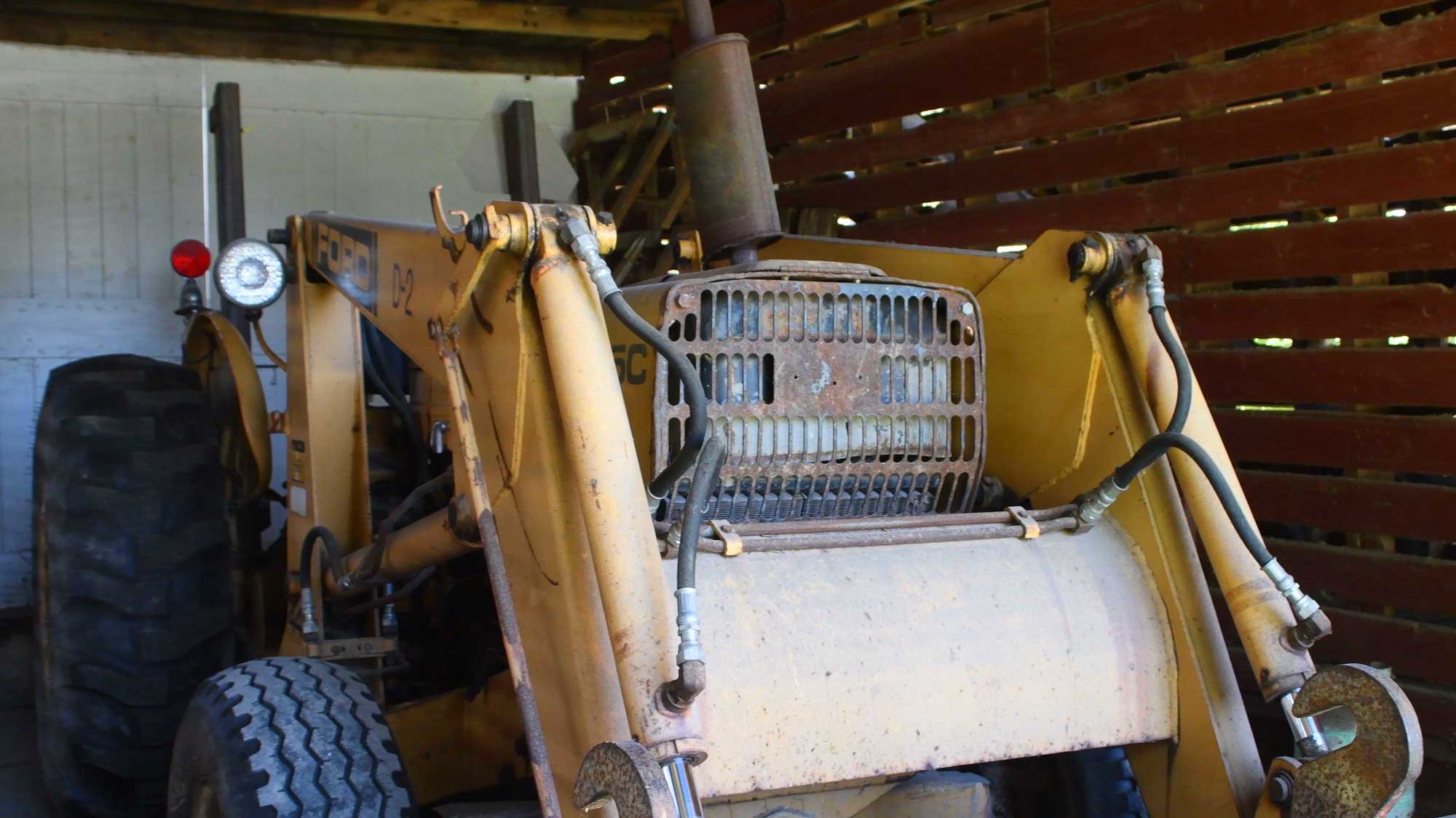 Tractor sitting idle inside of a corn crib.