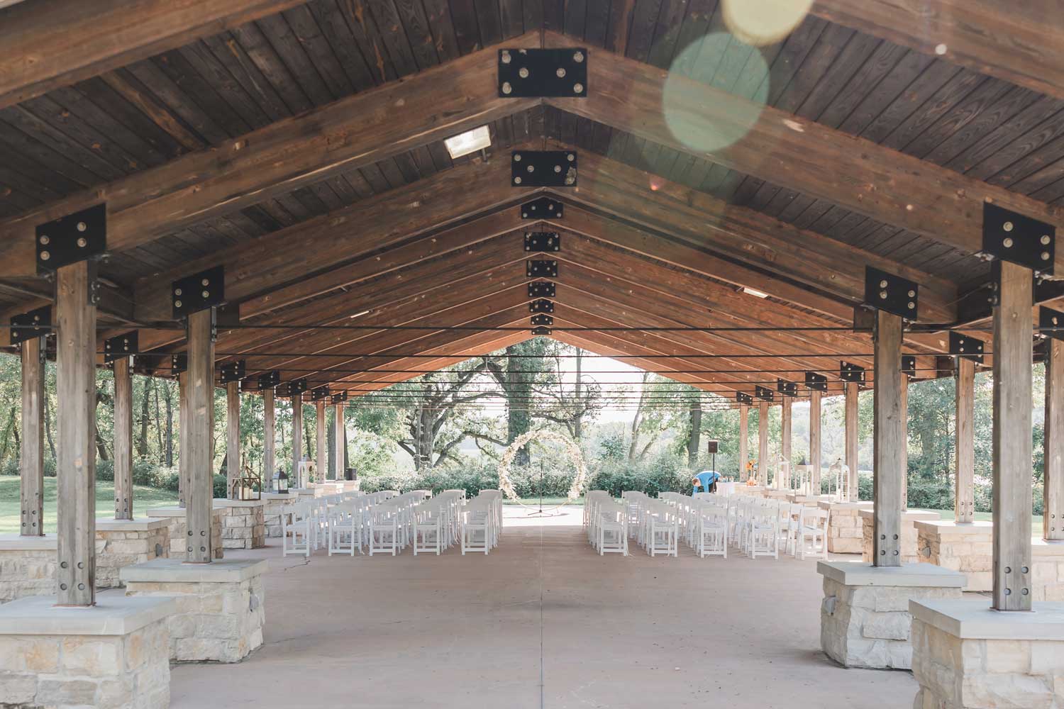 Wedding ceremony setup under outdoor shelter.