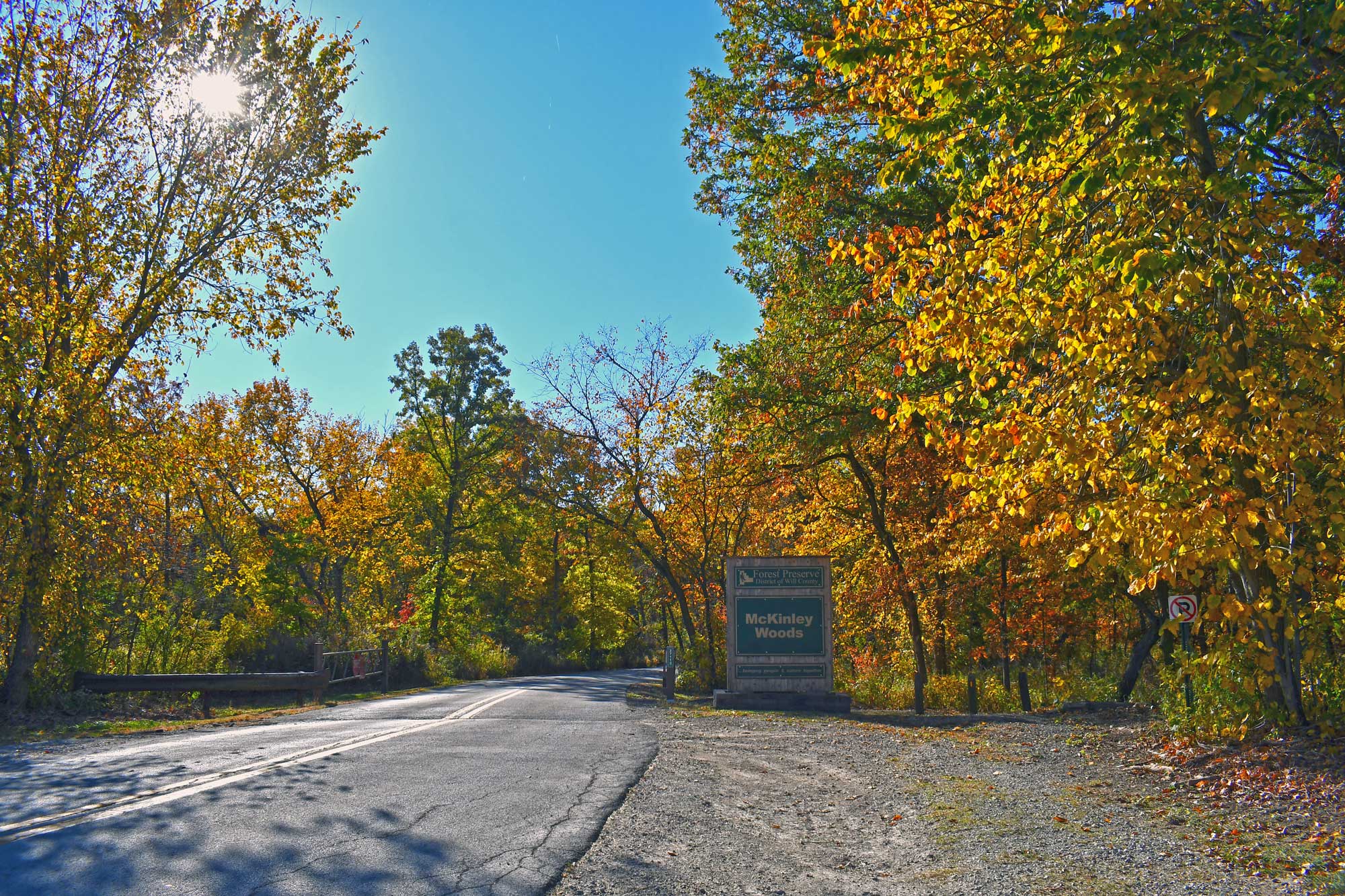 Preserve sign next to entrance road surrounded by fall colored trees.