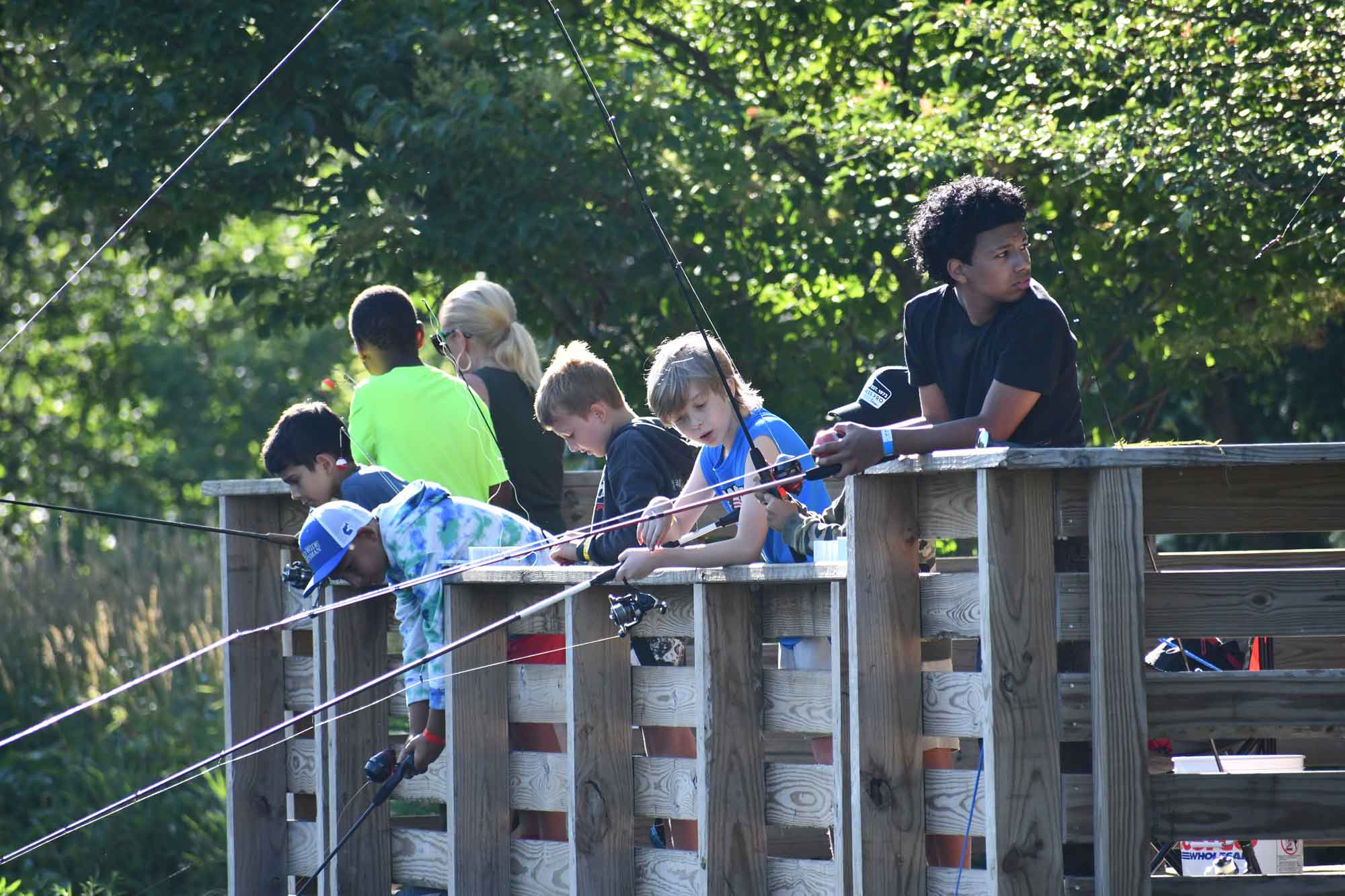 a group of people fishing on a bridge