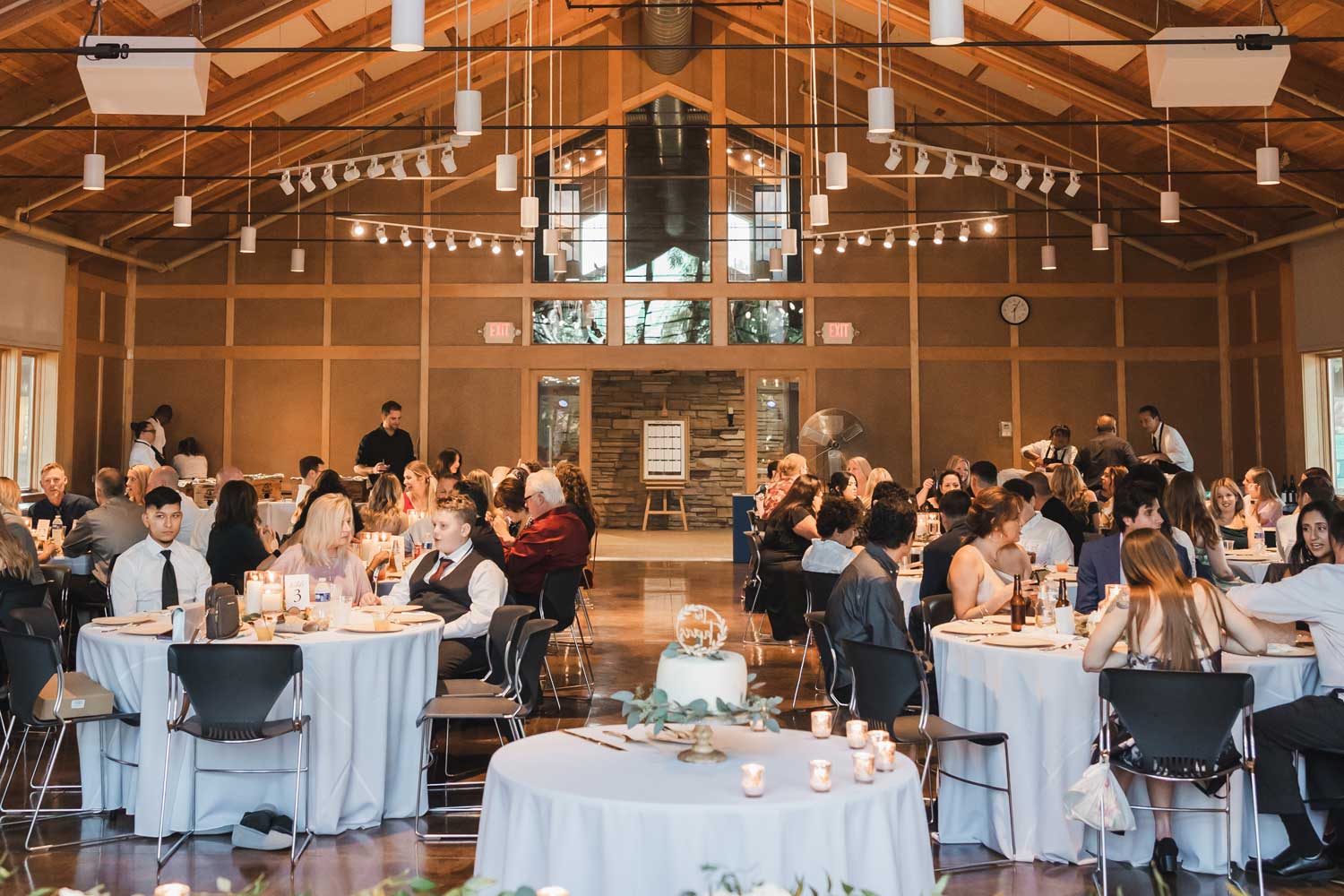 Guests sittings at tables before wedding reception starts.