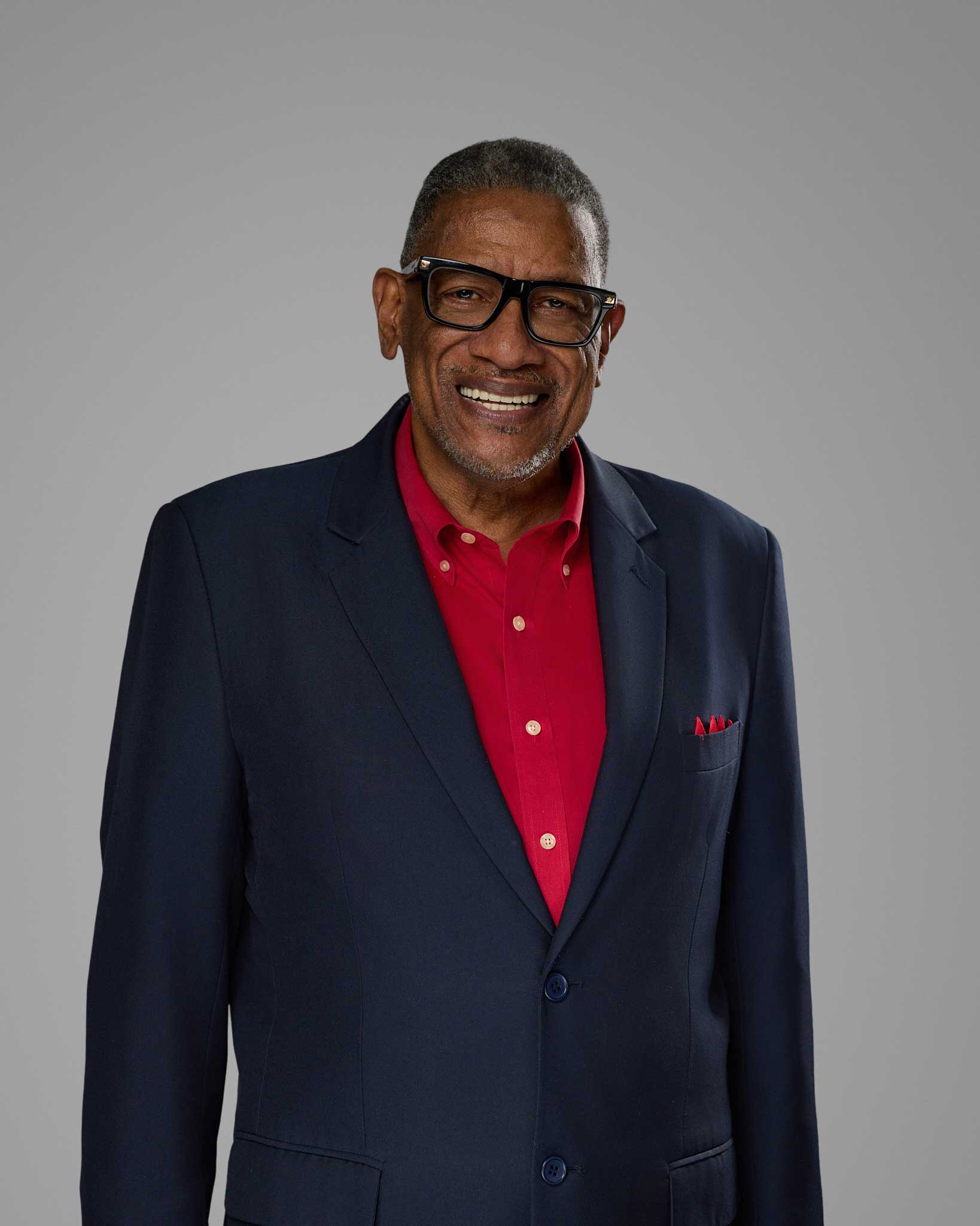 a man in a suit and glasses smiling