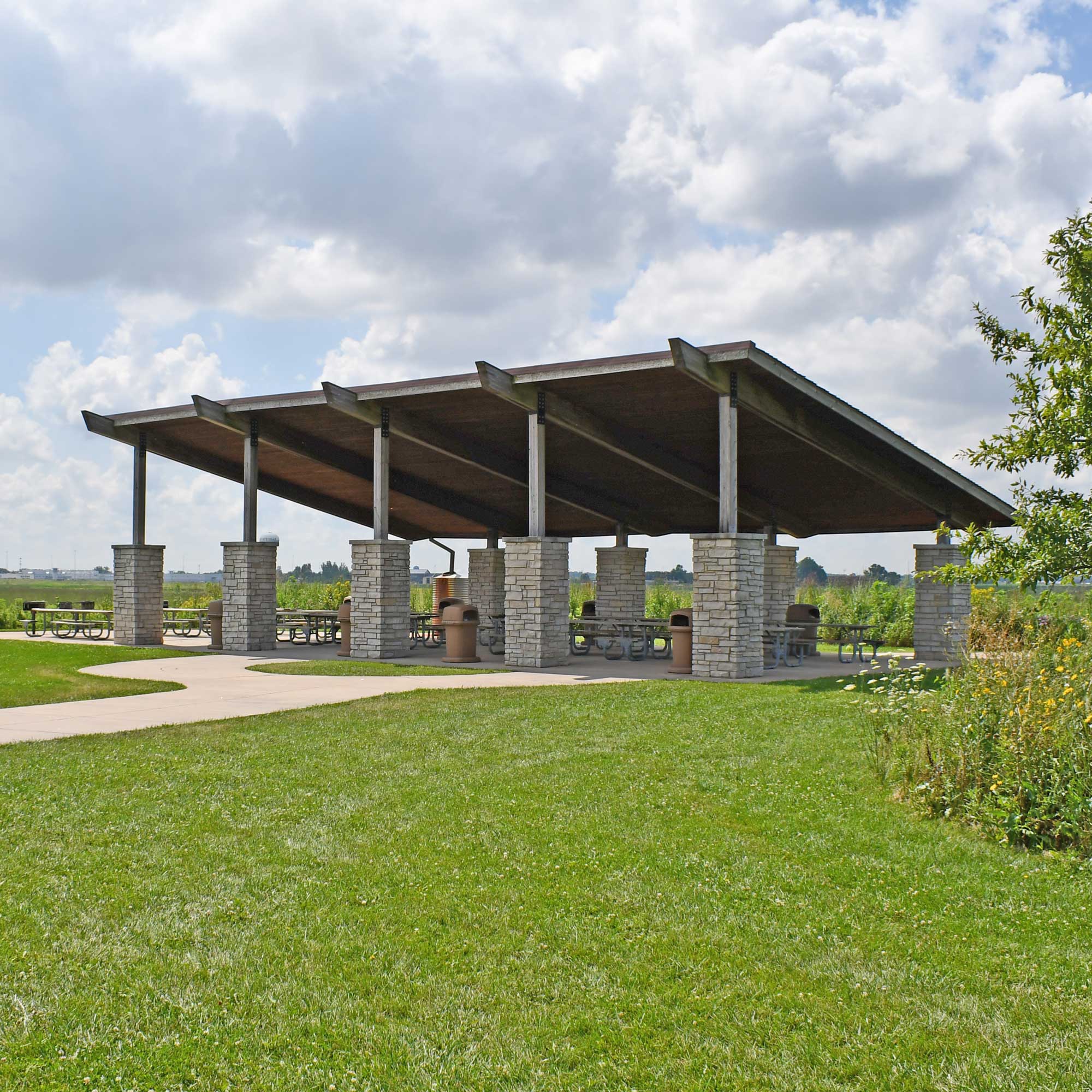 Picnic shelter surrounded by prairie grasses.