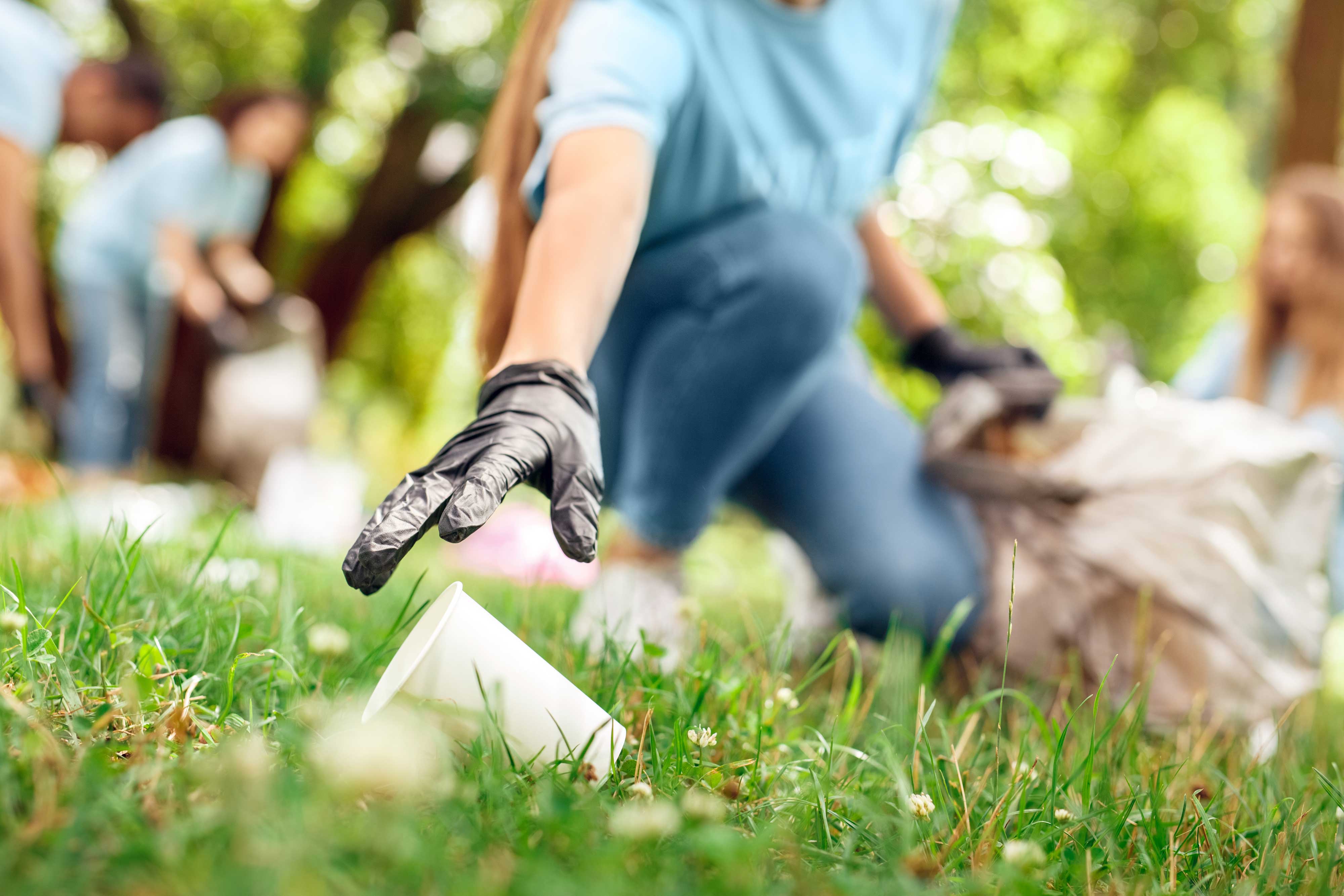 A person with a trash bag picking up litter.