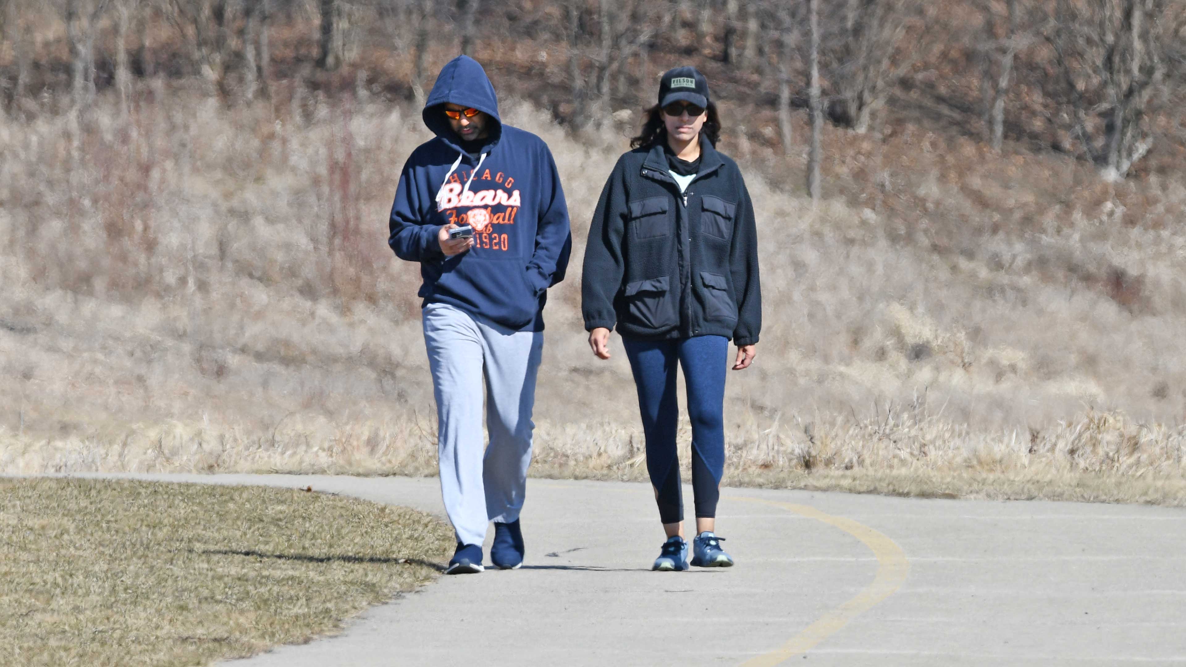 A man and woman walking on a trail.