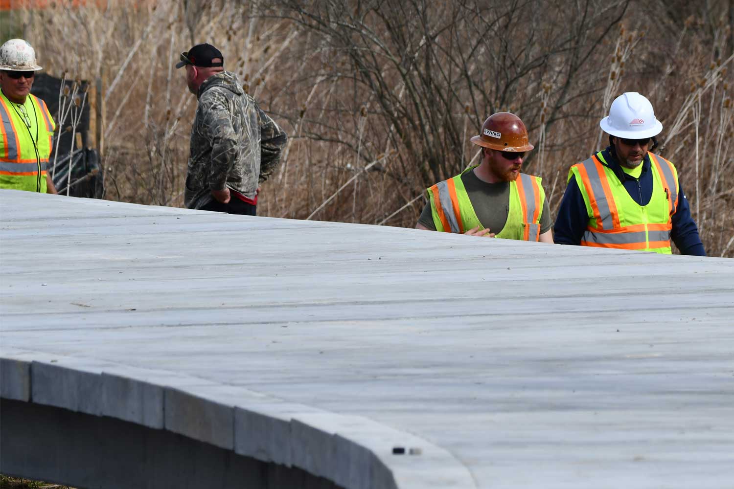 Construction workers walking on a trail.