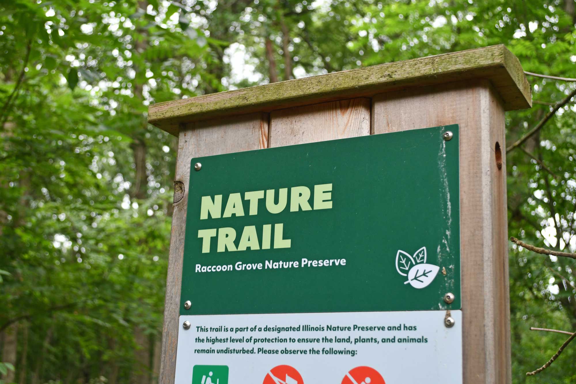 Trail sign with trees in the background.
