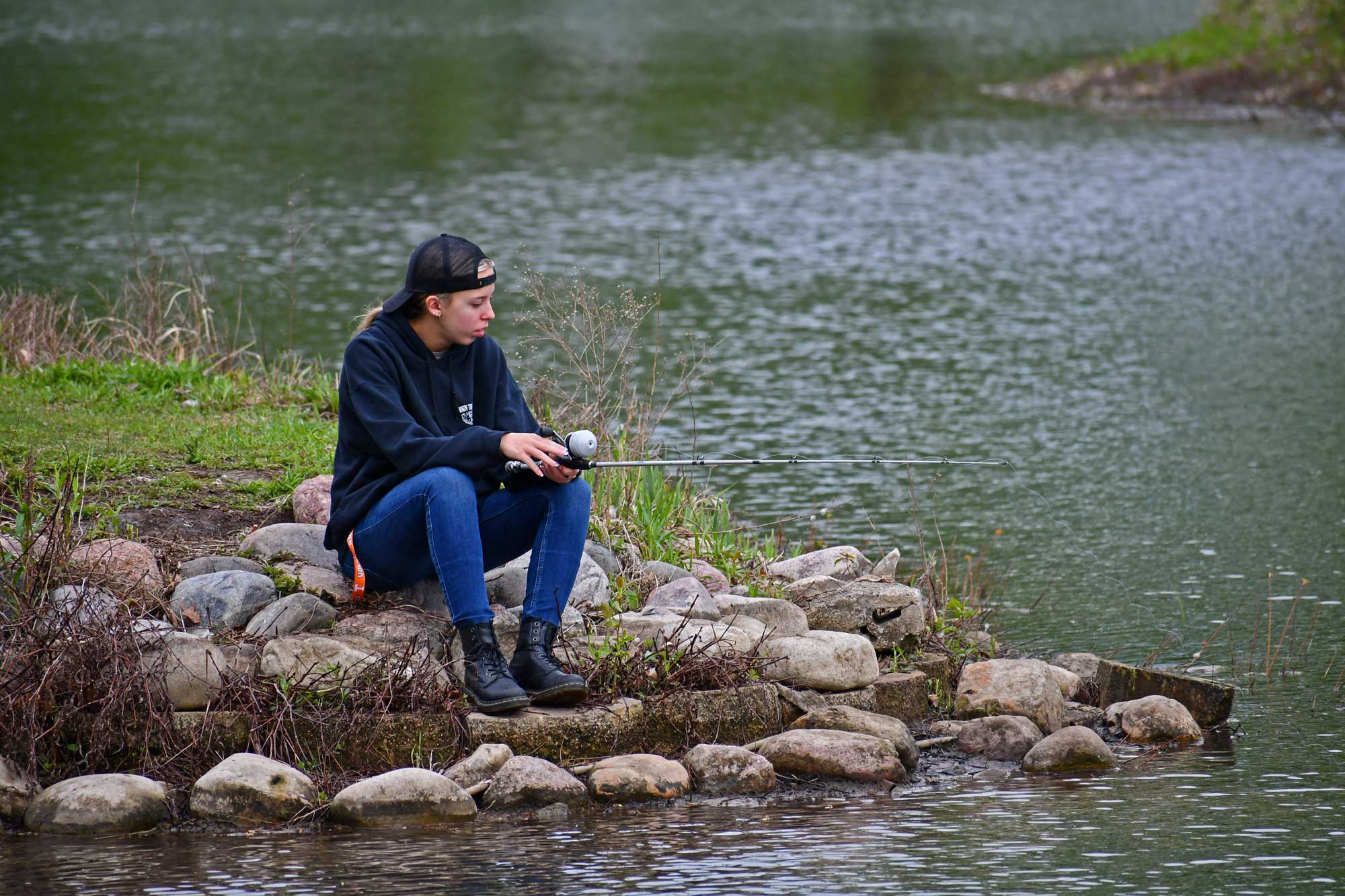 Person sitting down and fishing.