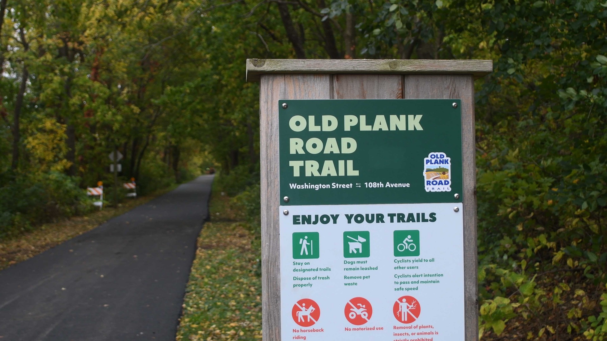 A view of a trailhead sign that says Old Plank Road Trail.