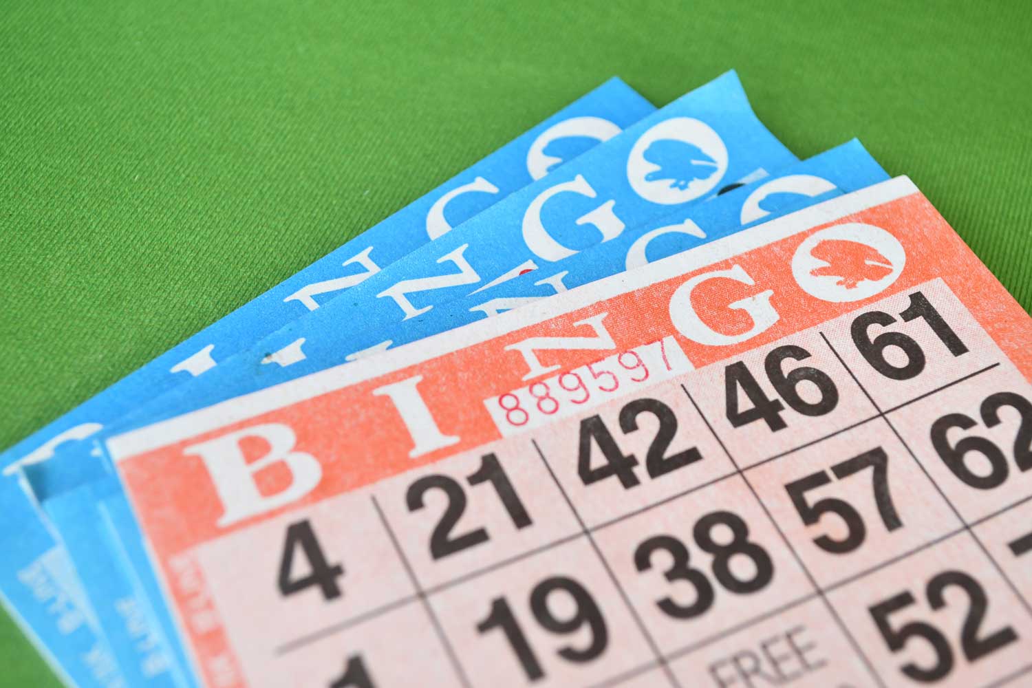 A stack of red and blue bingo cards on a green background.