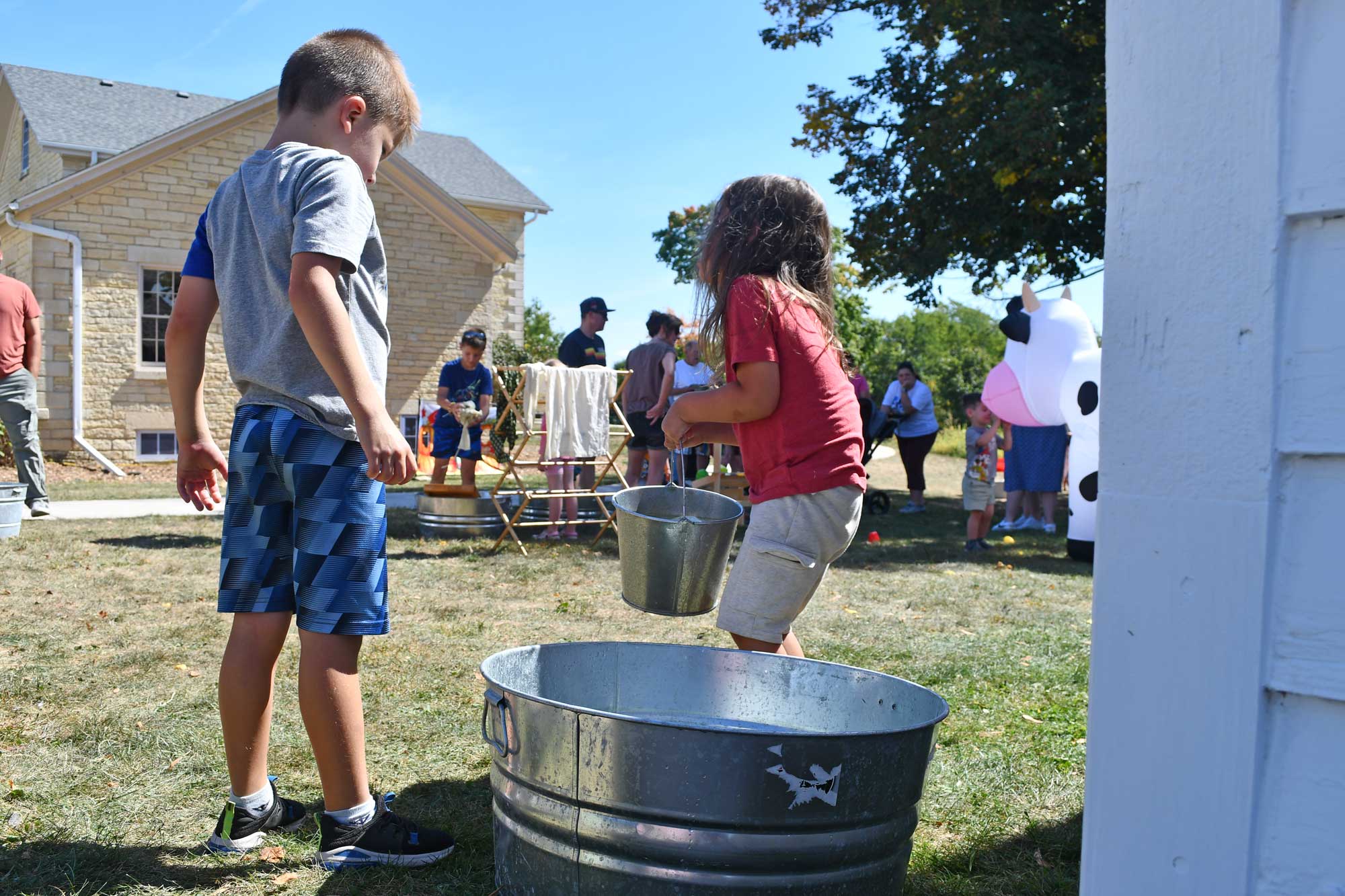 a boy and girl playing with buckets in a bucket