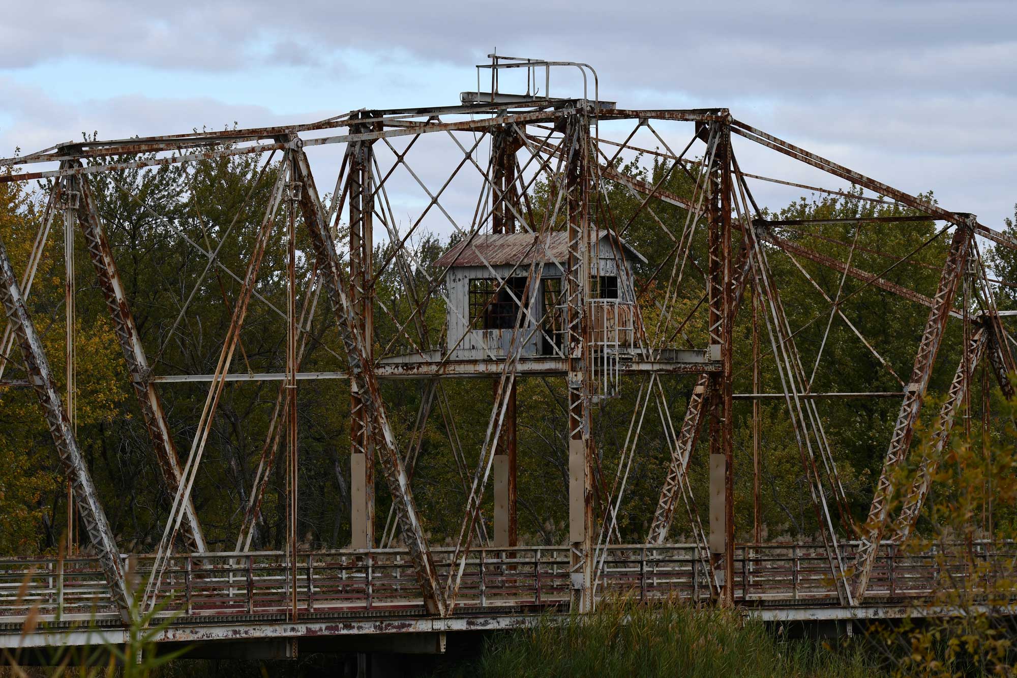 Bridge over the water with trees in the background.