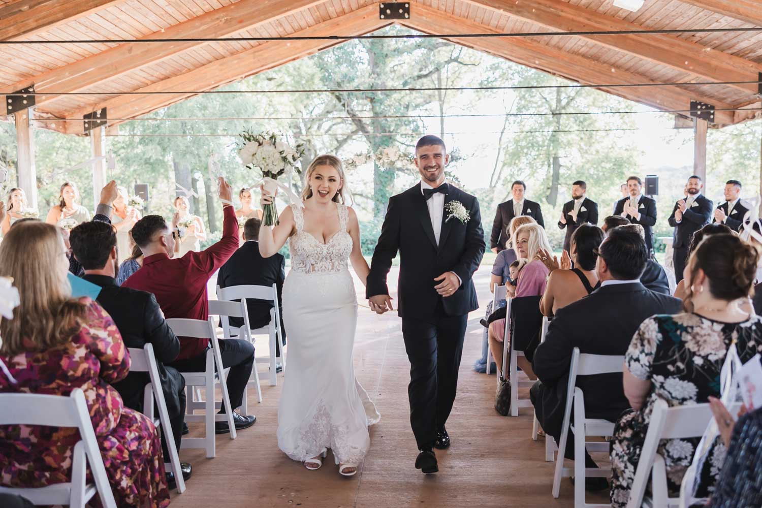Newly married couple walking down aisle after ceremony.