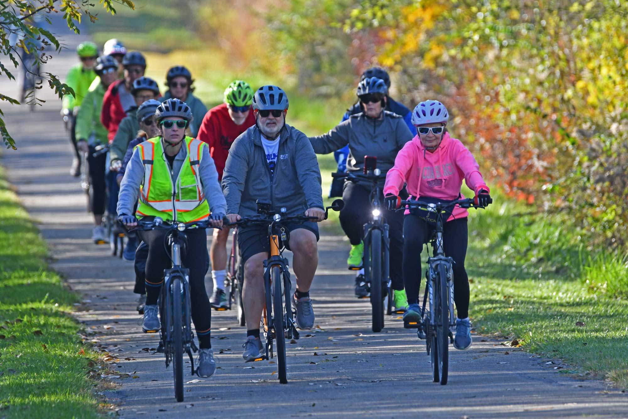 a group of people riding bicycles on a path