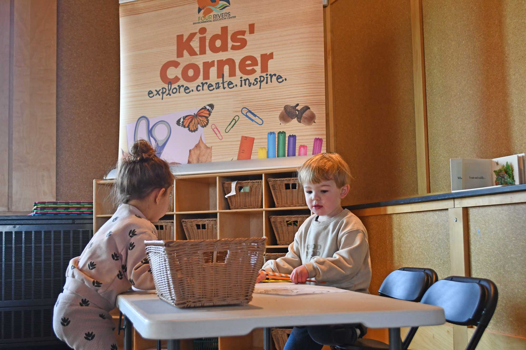 Two kids using kid's corner area doing crafts.