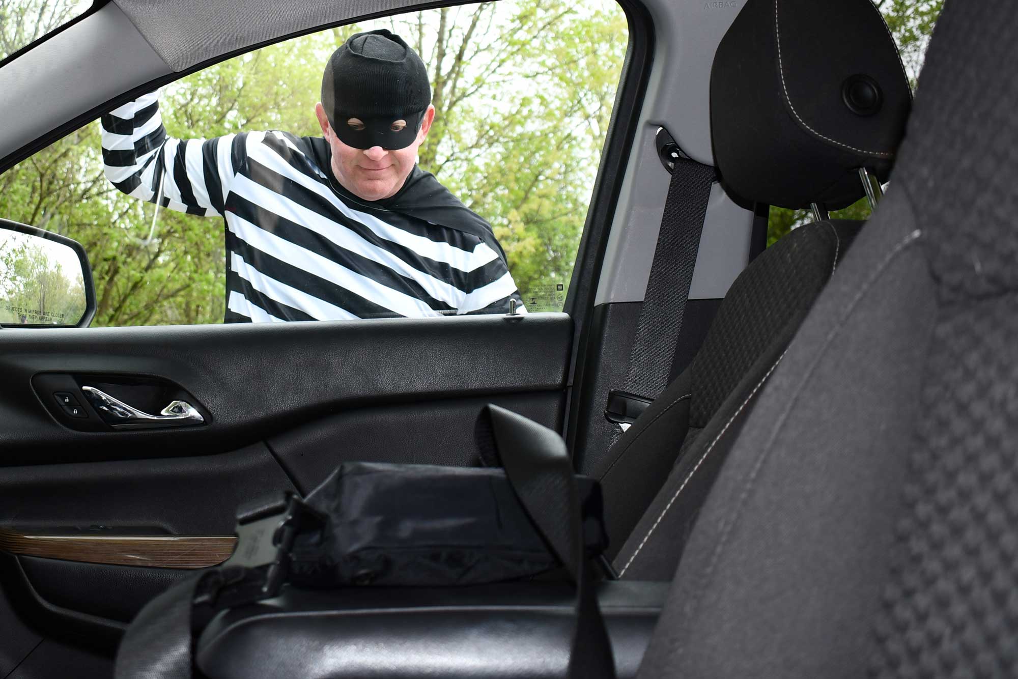 A goofy-looking robber tries to smash a window.