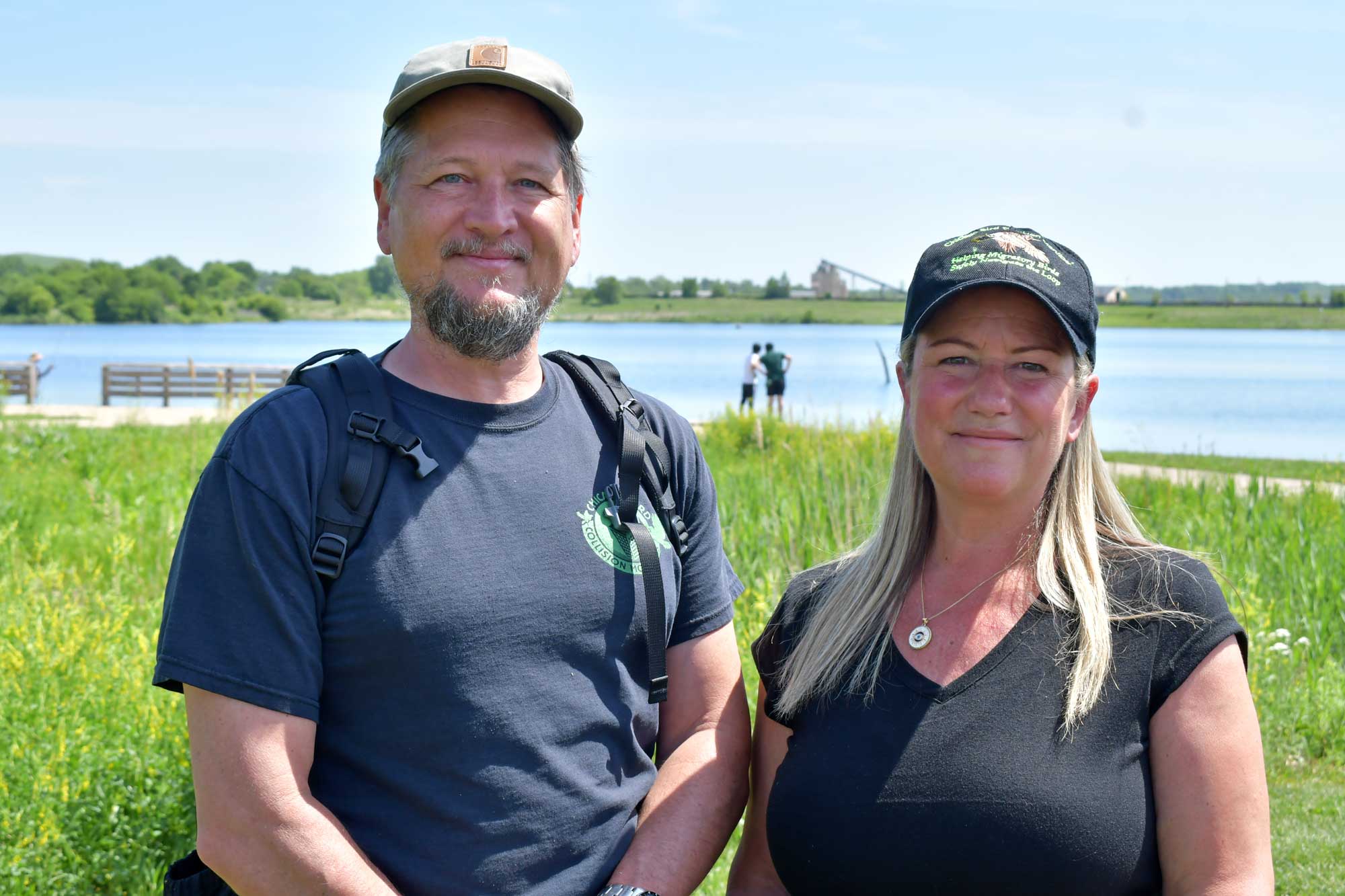 a man and woman standing in front of a body of water