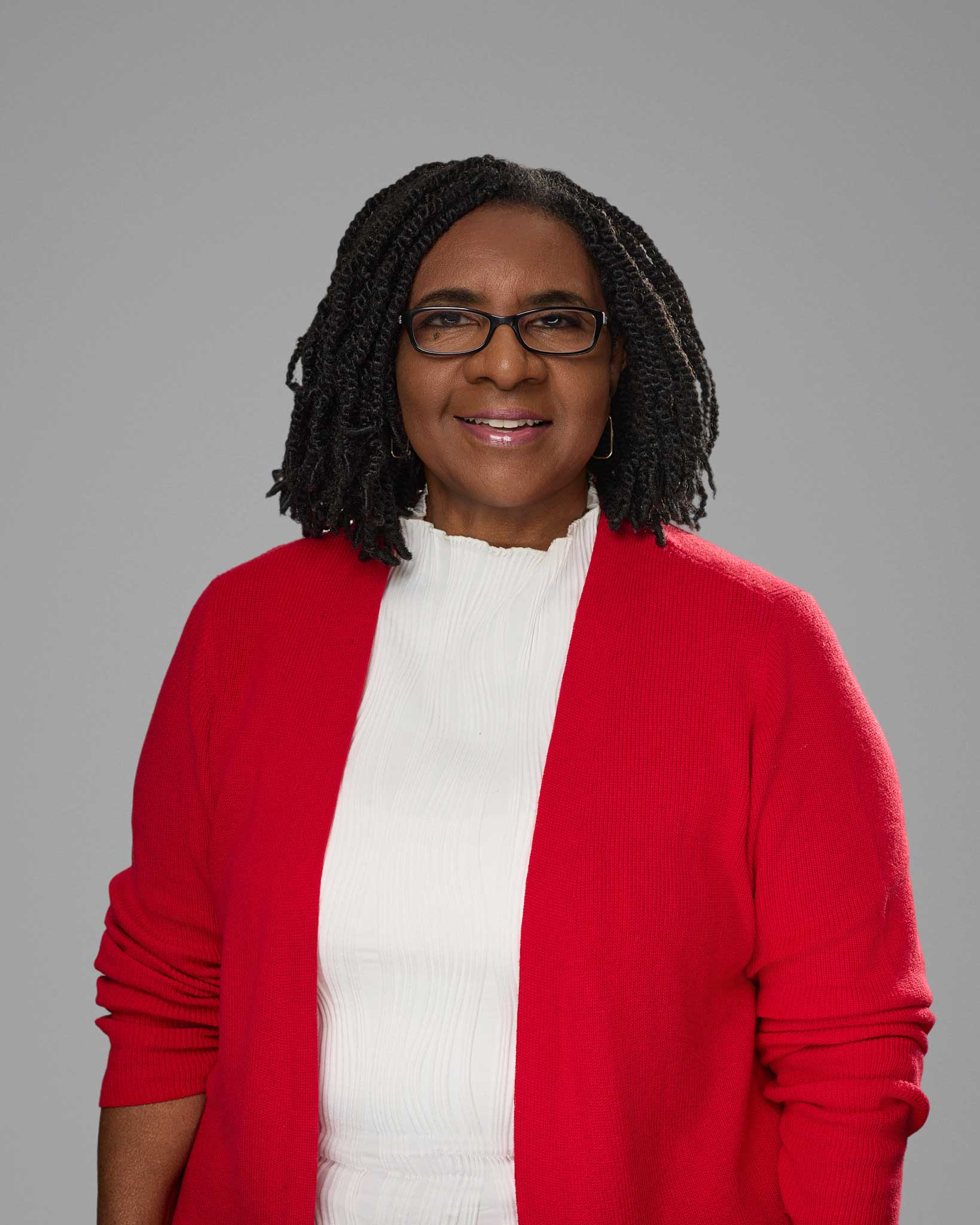 a woman wearing glasses and a red cardigan