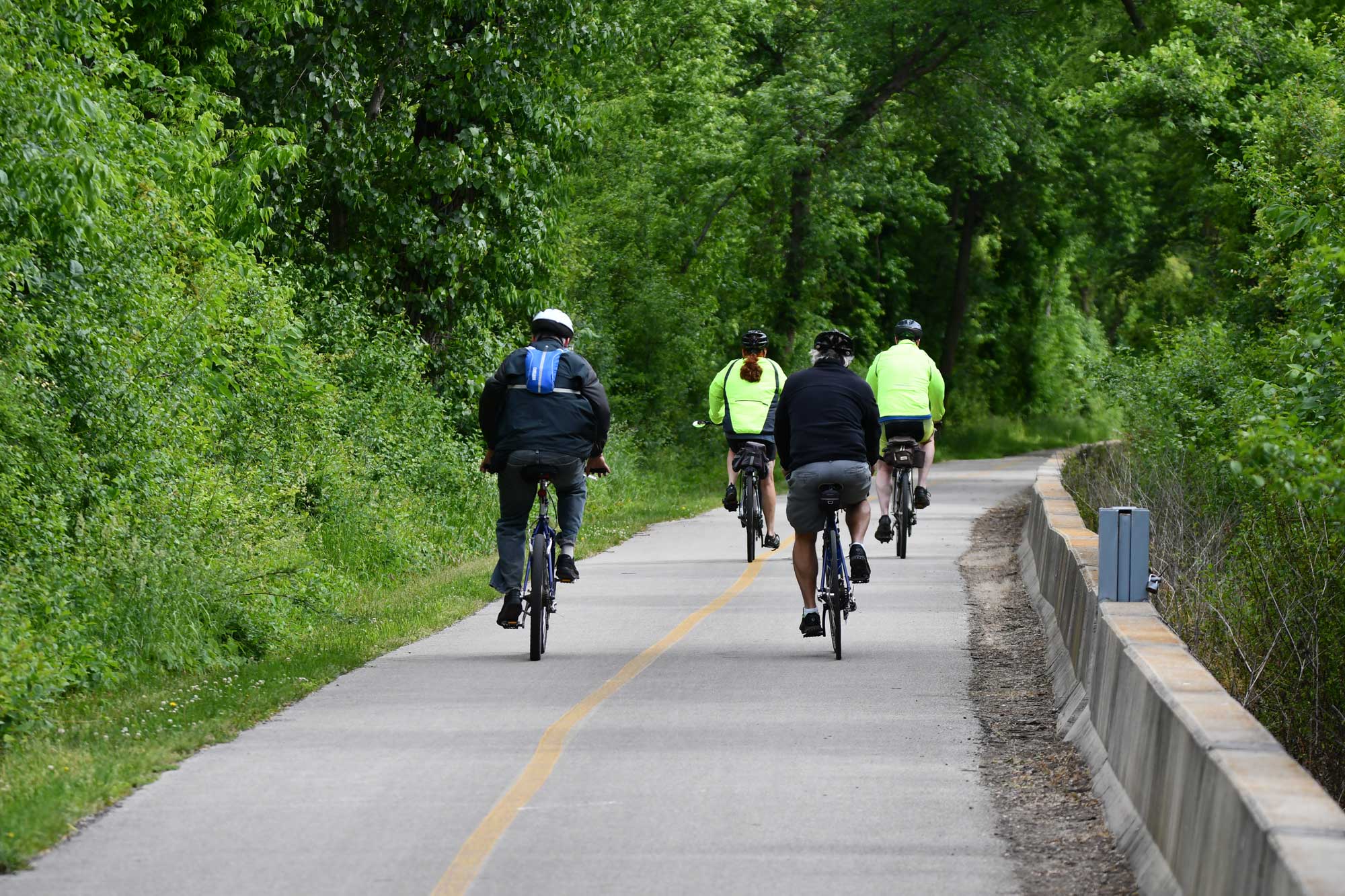 People biking on a paved trail.