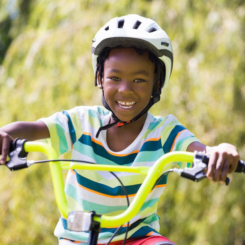 A girl on her bicycle smiling at the camera.