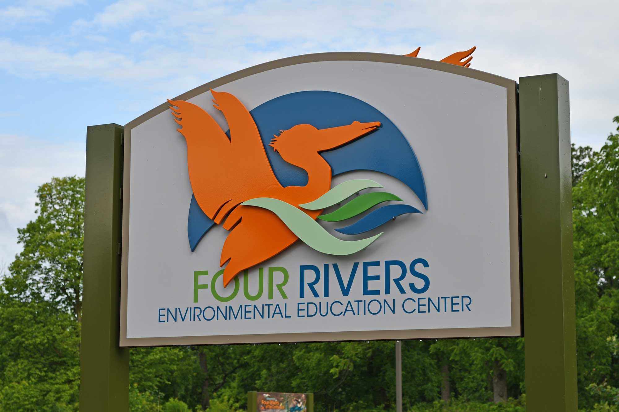 Four Rivers nature center sign with trees in the background.