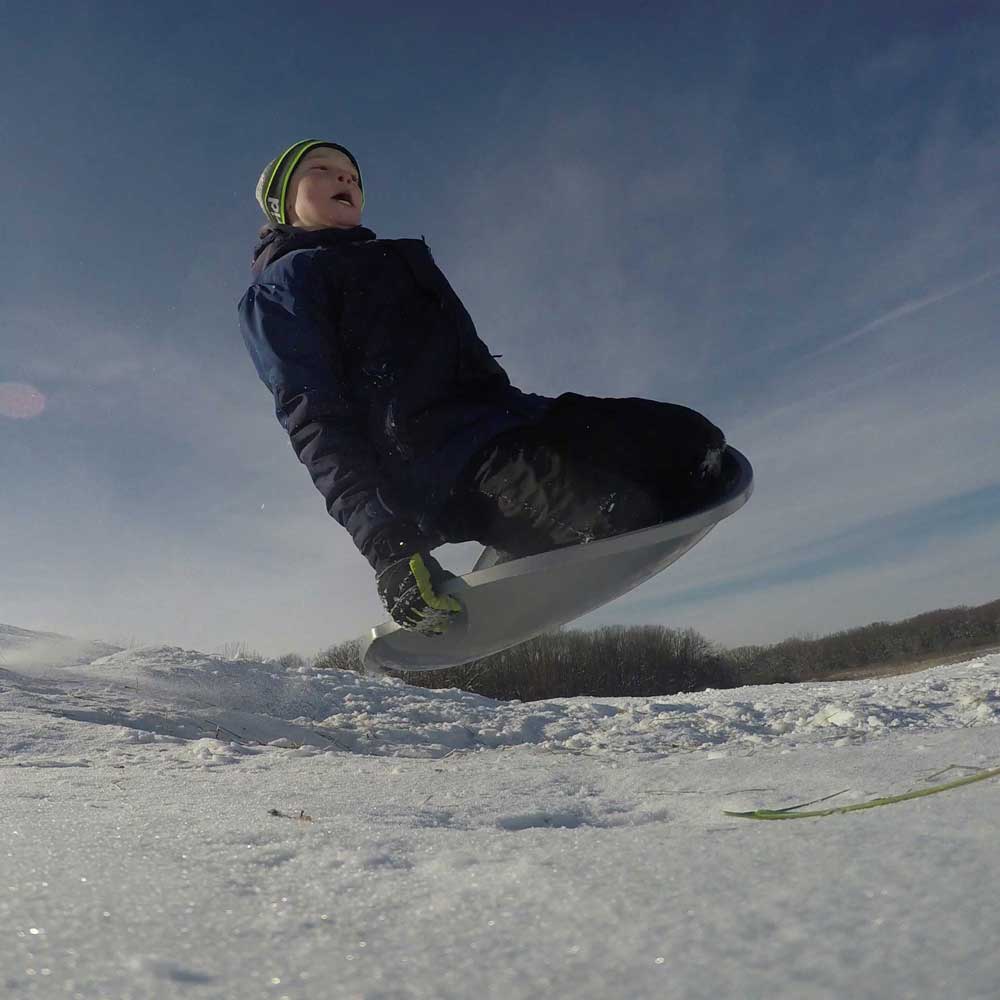 A person sledding down the hill at Goodenow Grove.