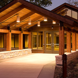 The entry area to a visitor center lit up at night.