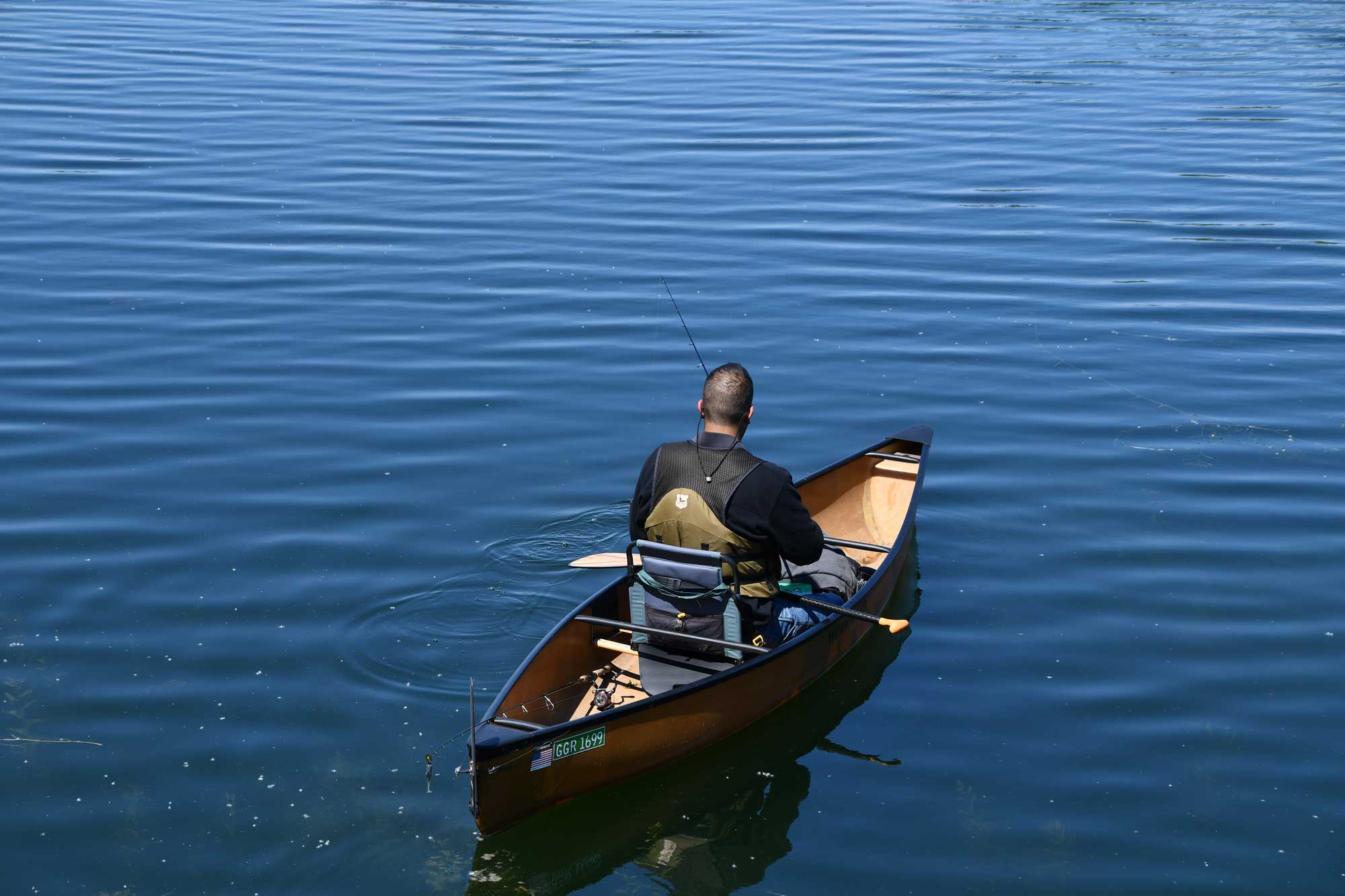 Person canoeing with water in the background.
