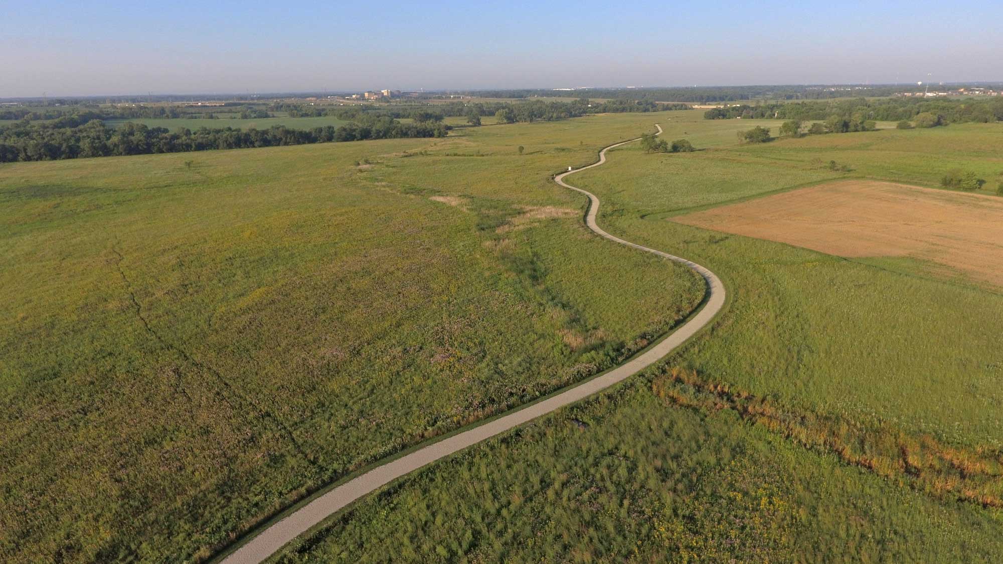 Aerial view of a limestone trail lined by grasses and vegetation.