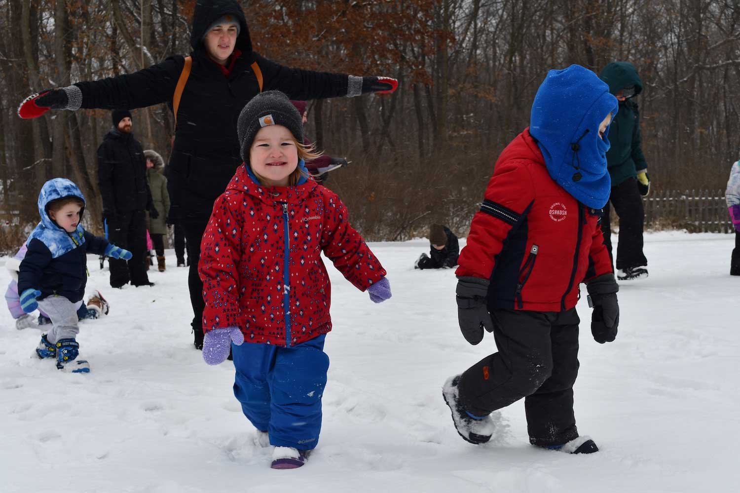 Young children in snow gear walking in the snow.