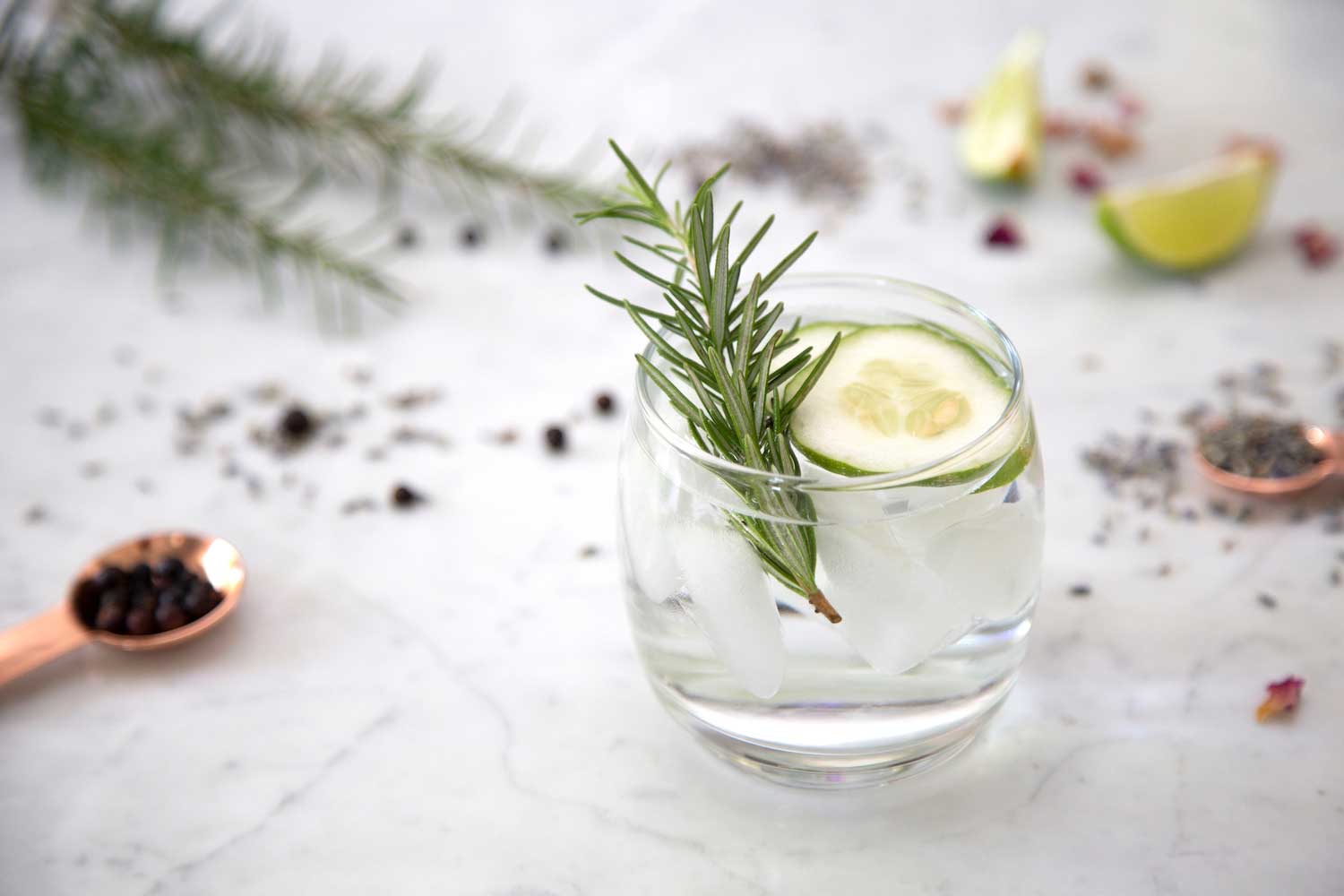 A cocktail on a table surrounded by botanicals.
