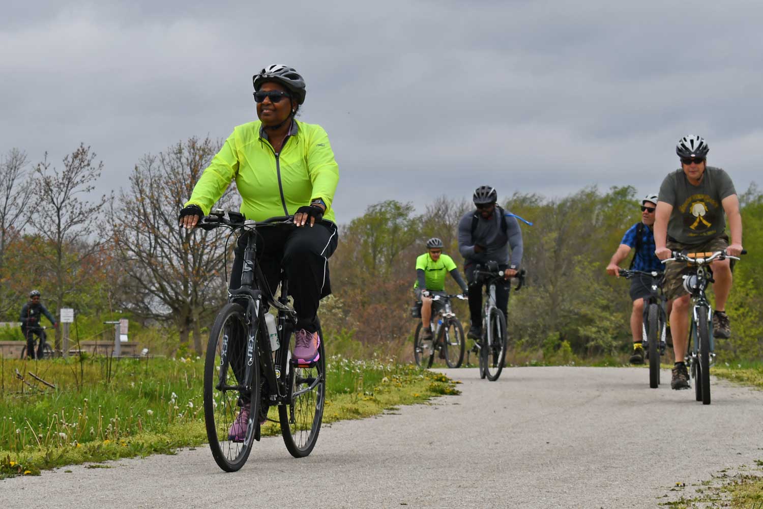 Group of people riding bikes on a trail.