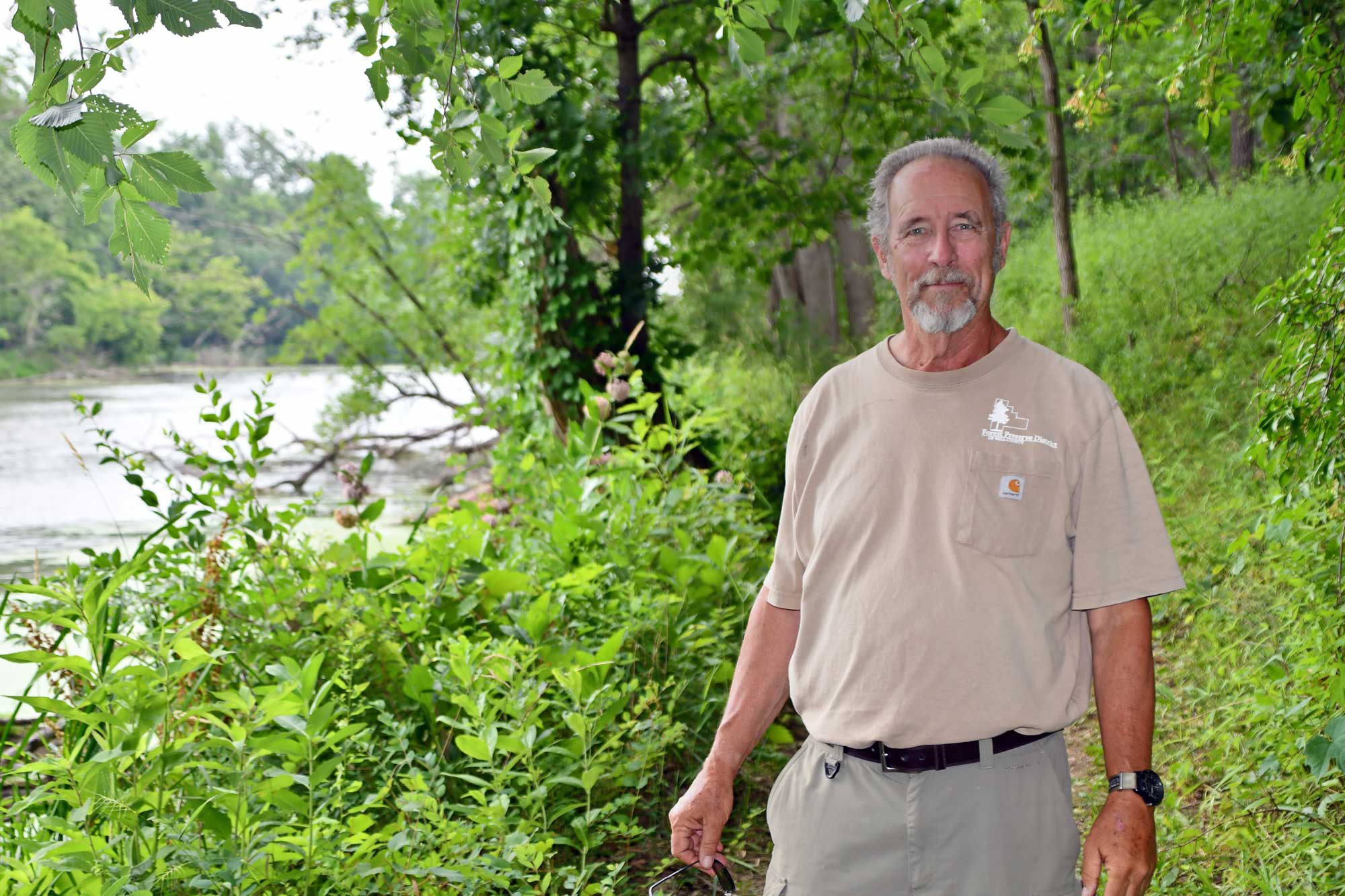 A man stands in the woods. 