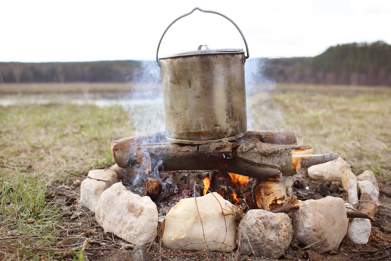 A large pot cooking over an open fire.