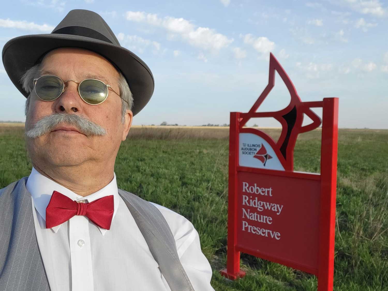 A person in costume standing in front of a preserve sign at Robert Ridgway Nature Preserve
