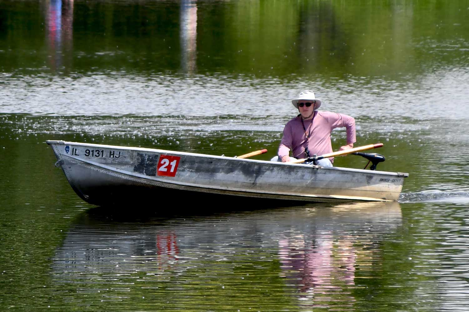 Person riding in a boat sitting near the back of the boat.