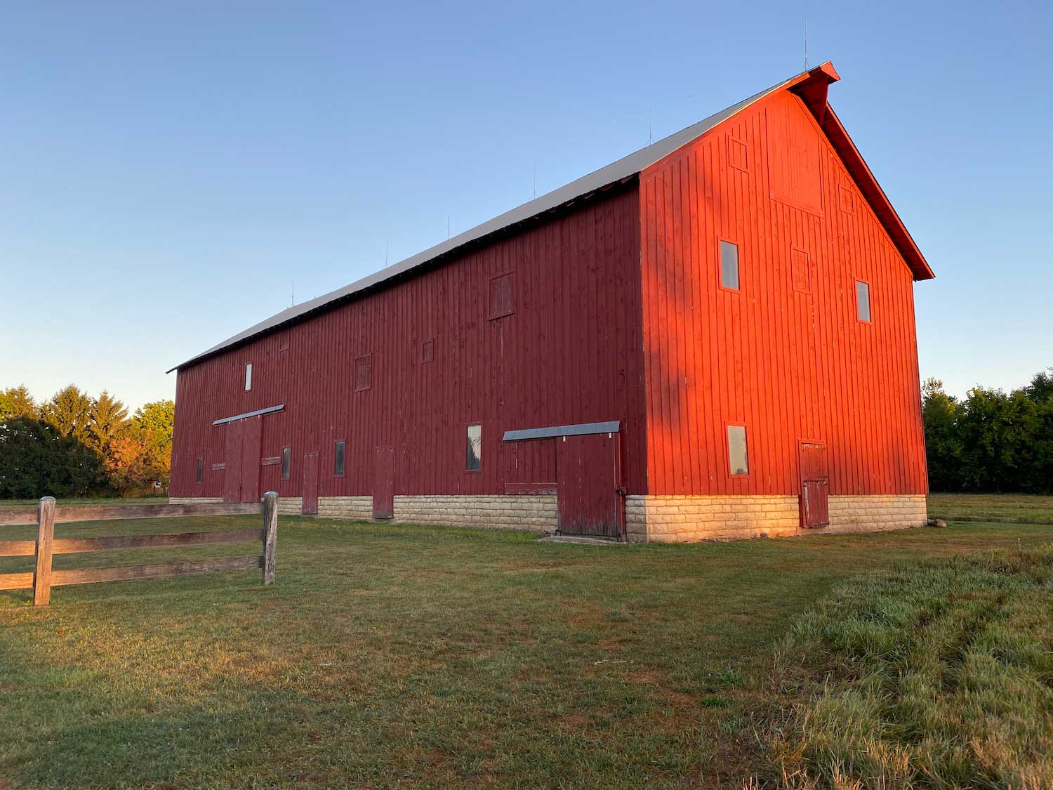 A red barn seen as the sun sets.