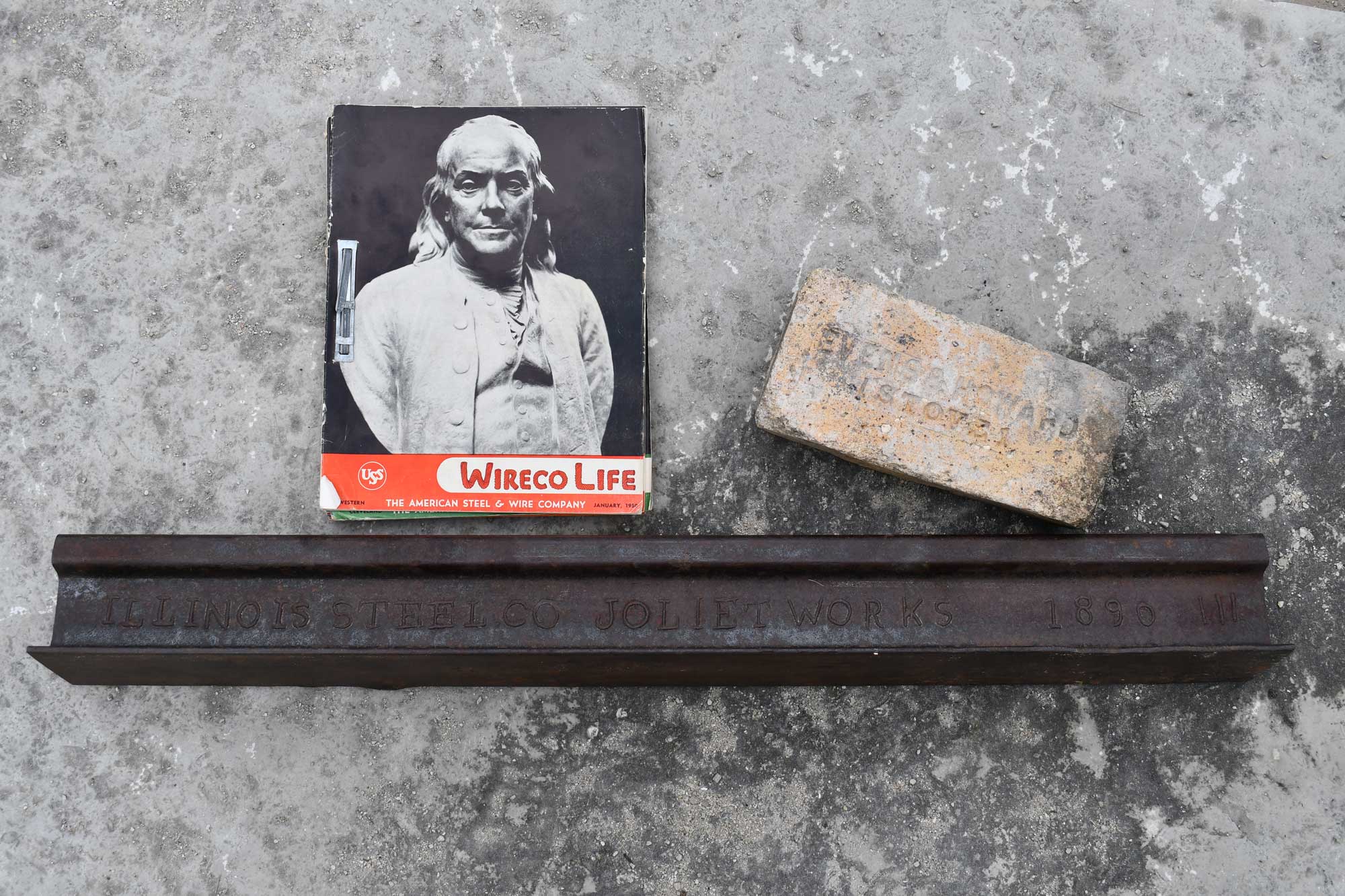 A display of artifacts from Joliet Iron Works, including a photo and a brick.