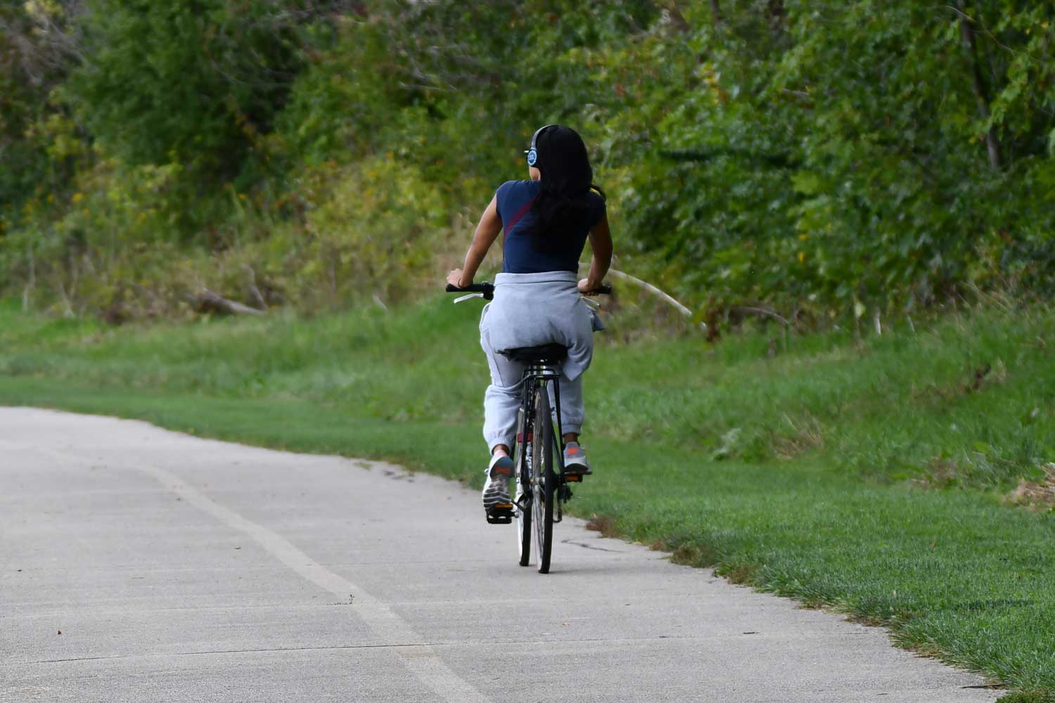 Person riding a bike on a paved trail.