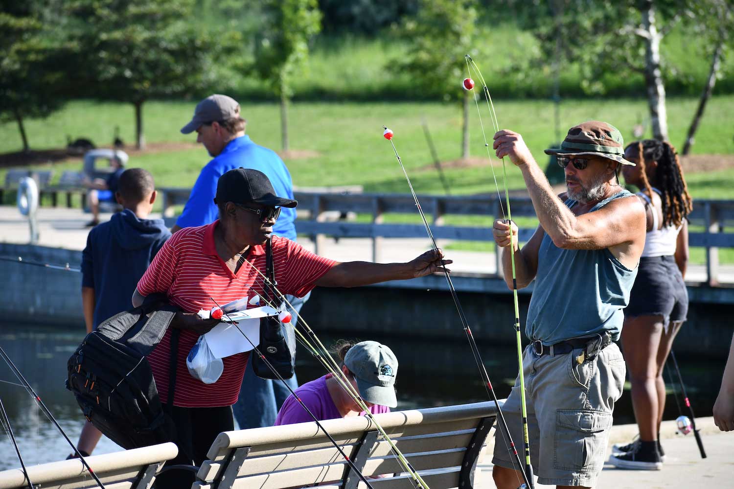 People fishing and preparing fishing poles along the shoreline.