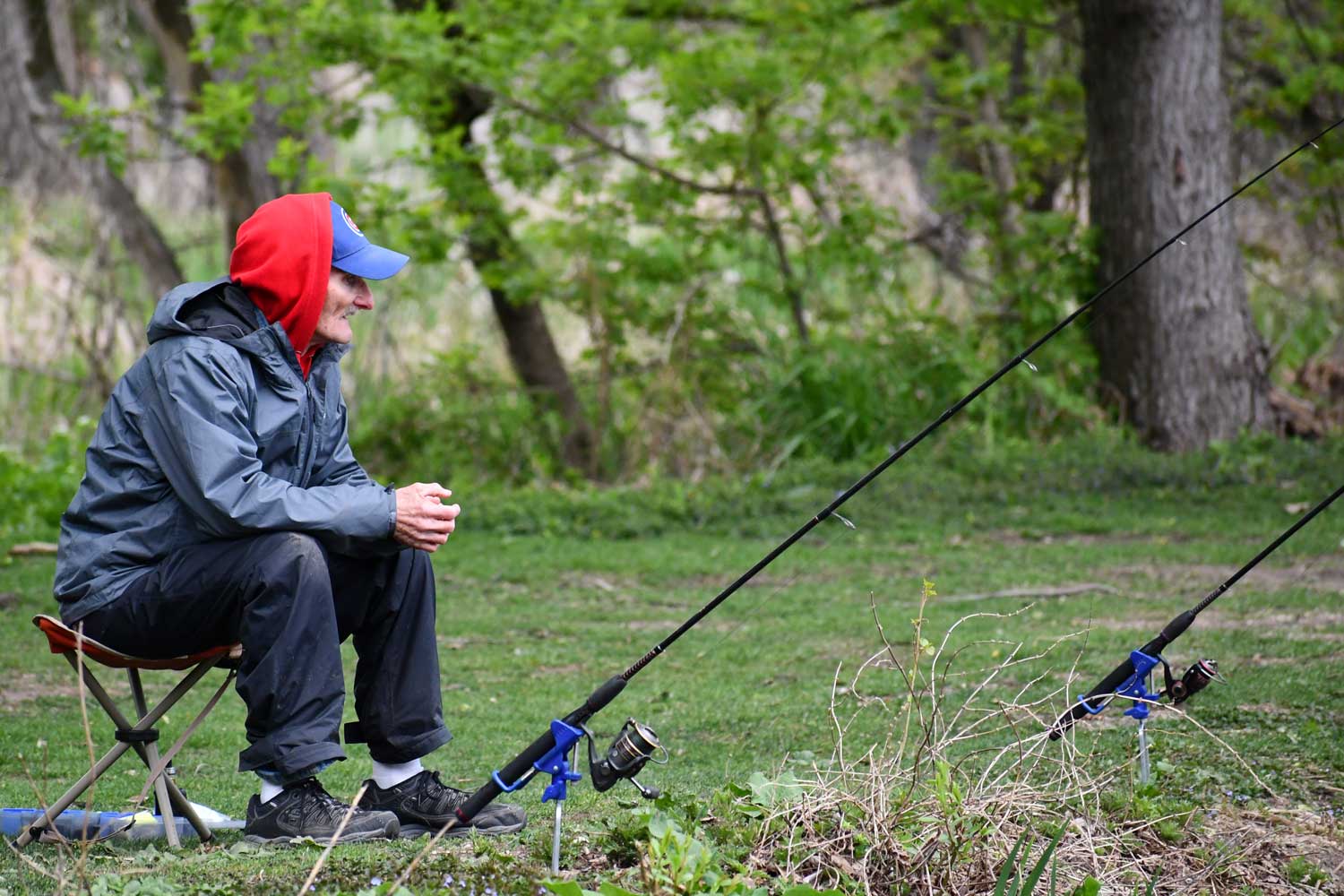 Person sitting near water while fishing.
