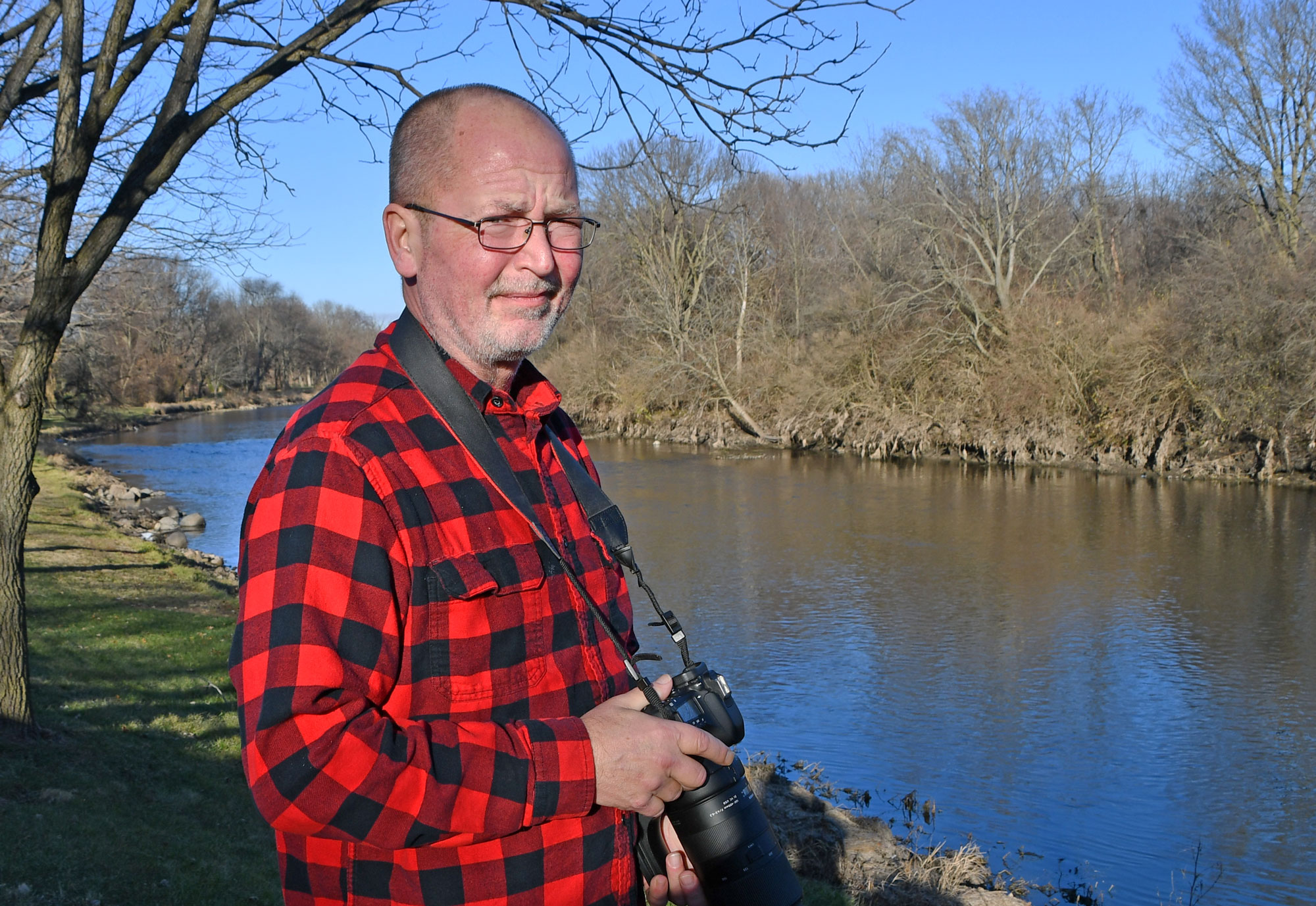 Man holding camera along the DuPage River