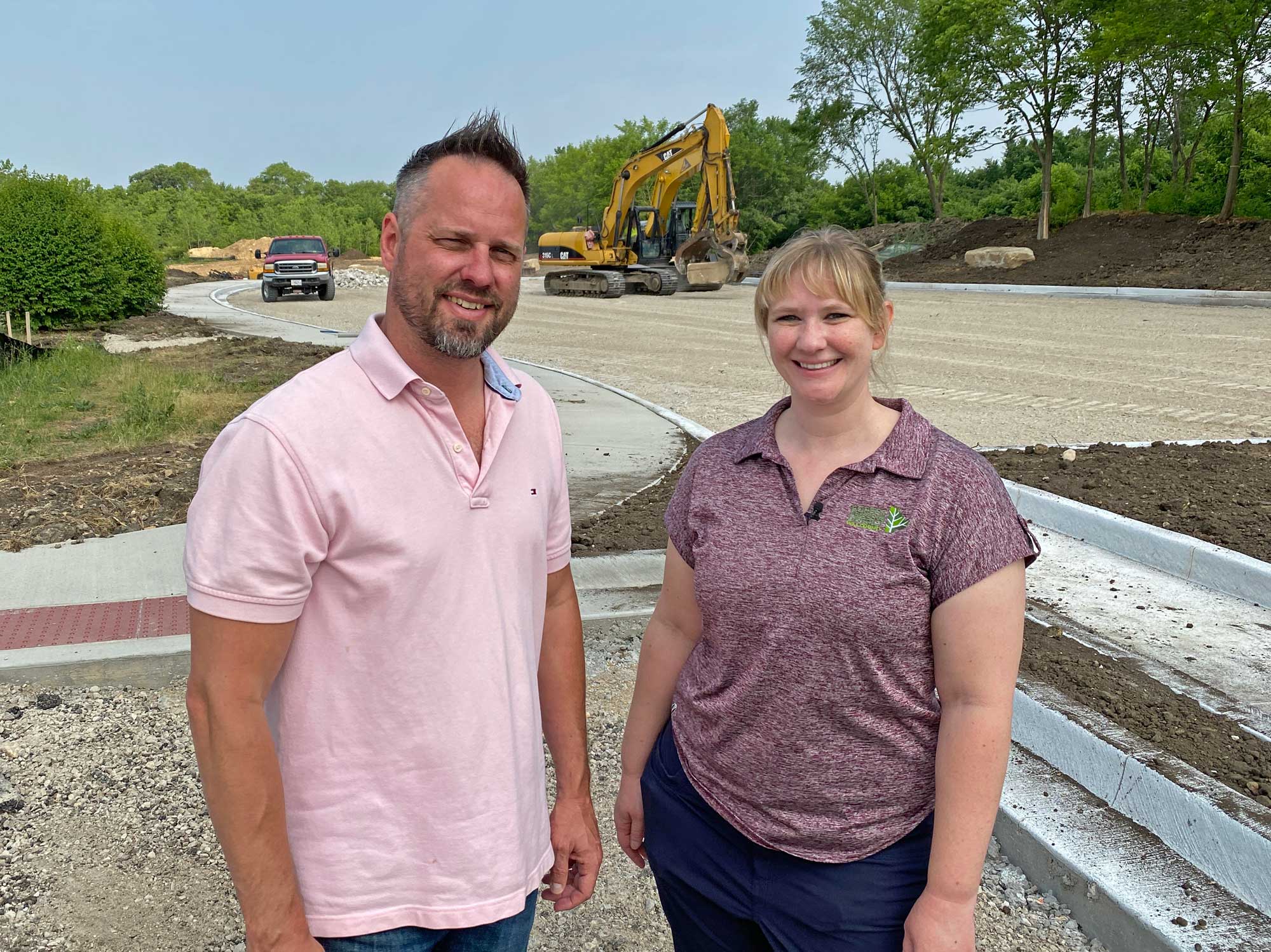 A man and woman stand in a construction area.